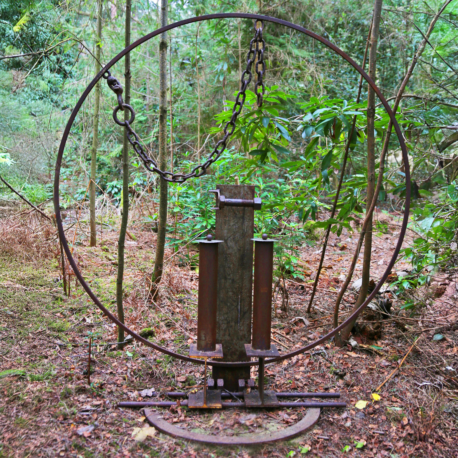 A furniture welded steel sculpture of a large abstract toilet roll holder.