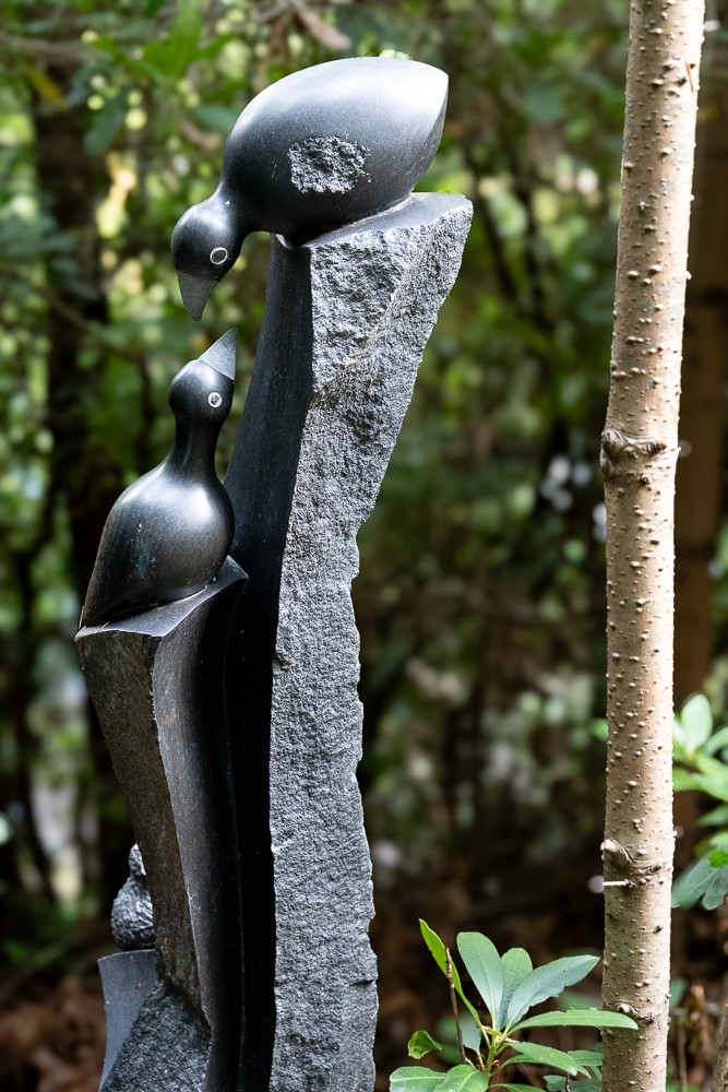 Presence in Parenting by Tonderai Marezva, A Shona sculpture made of Springstone of two birds perched on a tall stone and looking towards each other.