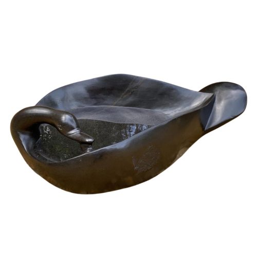Birdbath by Innocent Nyashenga is a Zimbabwean Springstone Shona sculpture of a swan laying down with a hallow back, this also doubles as a birdbath.