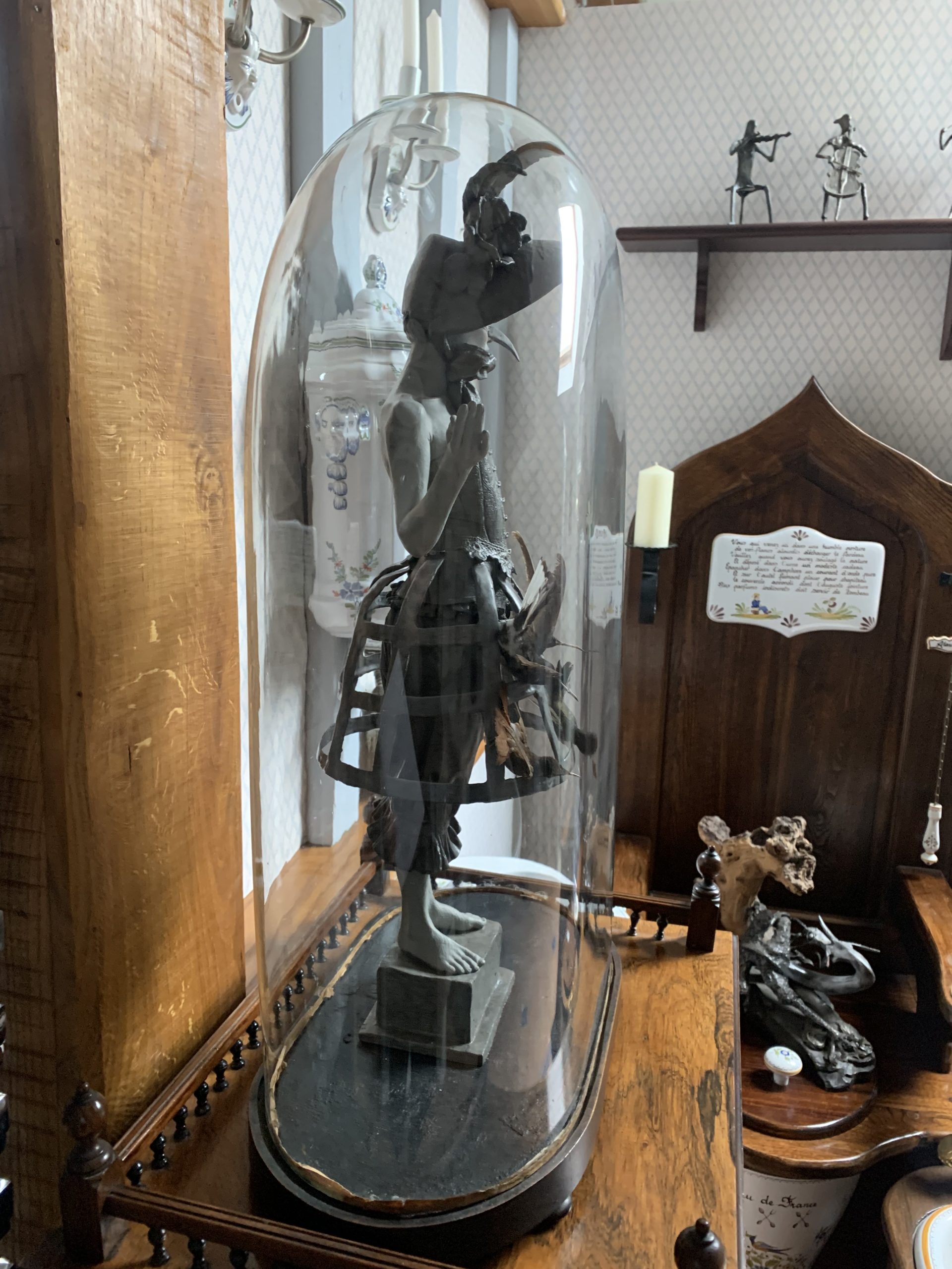 Bronze sculpture of a female figure wearing a corset, bloomers and hat. Her bustle is adorned with Taxidermy humming birds. Encased in Victorian glass dome, edition signed.