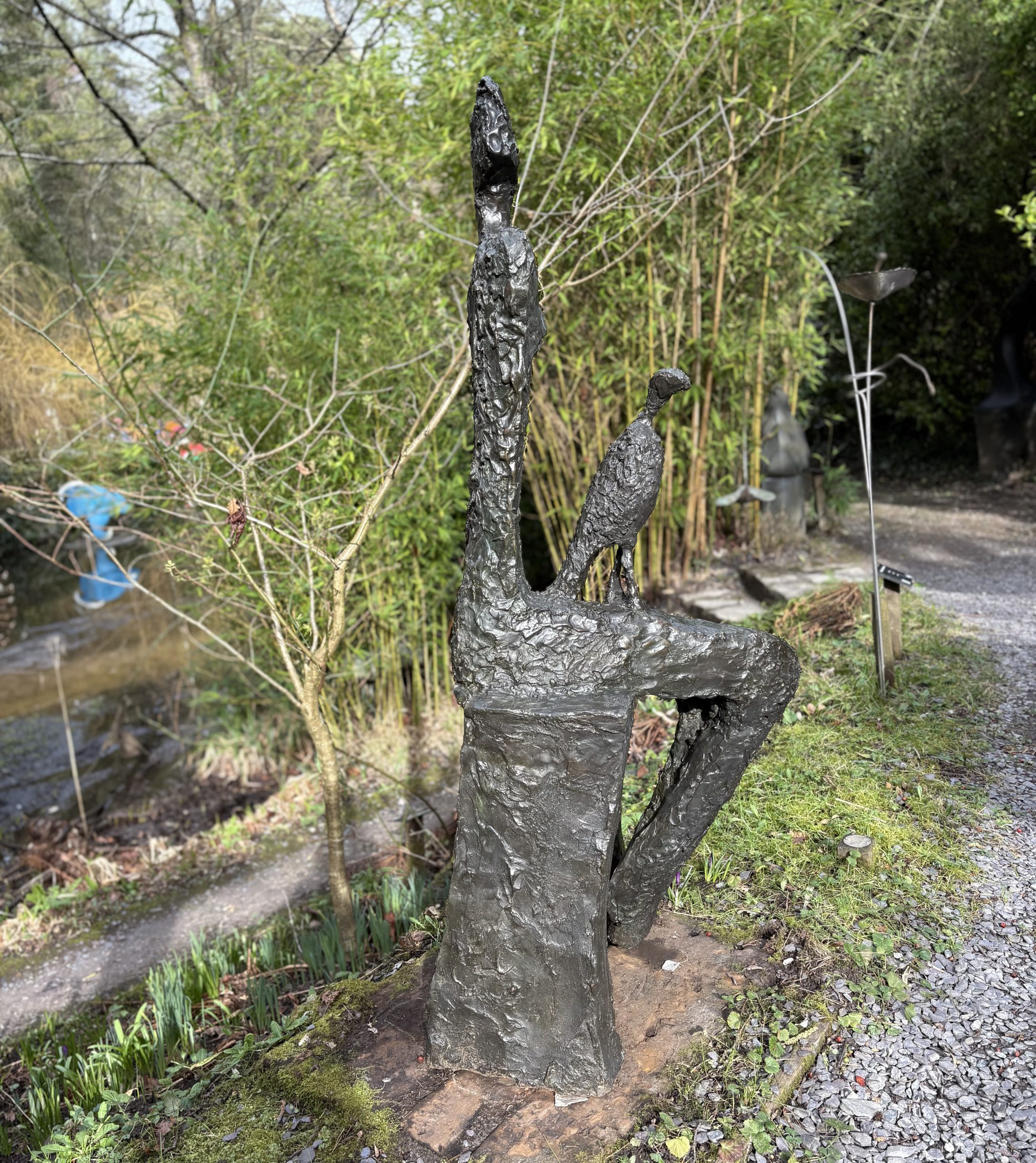 Companion by Wendy Fisher is a simple figurative bronze sculpture of a seated woman with a kestrel bird on her lap.