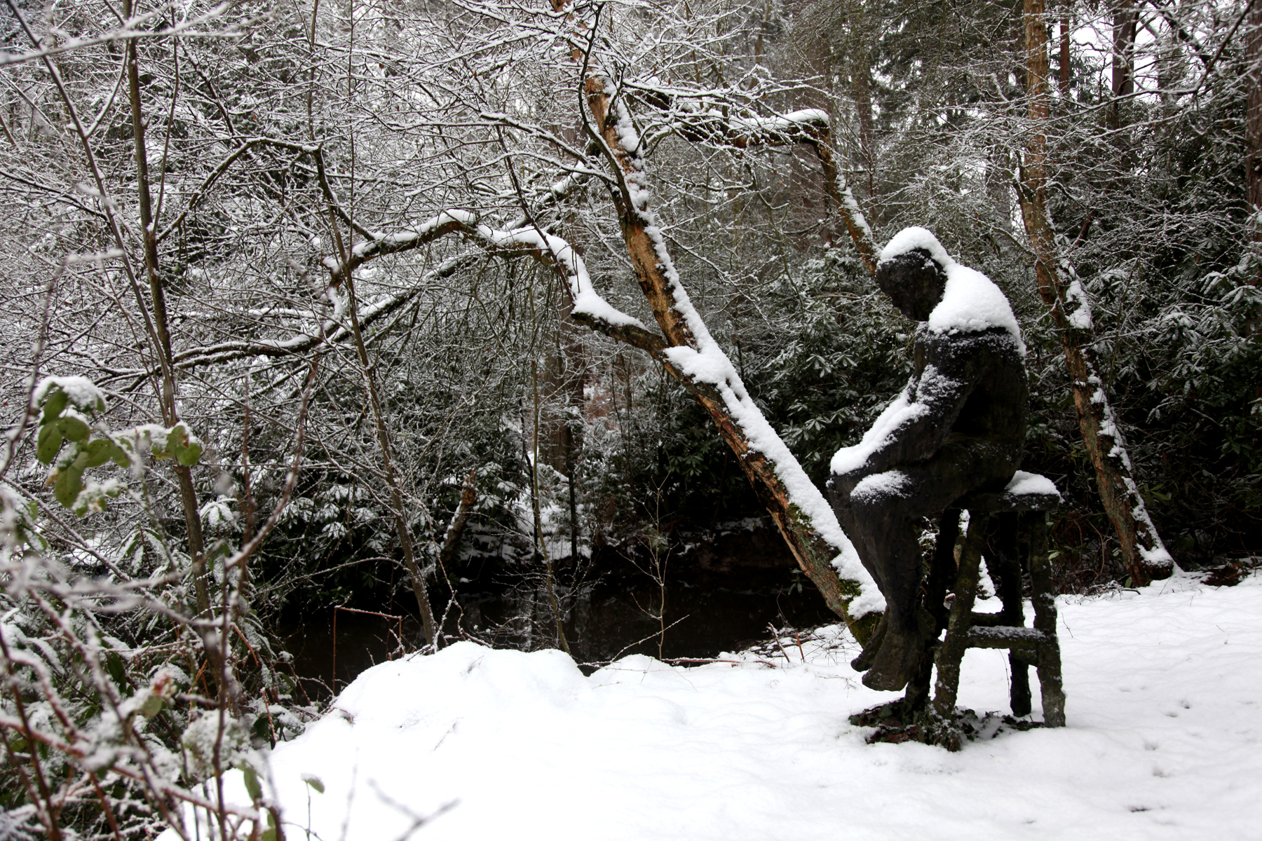 Dave by Sophie White is a figurative bronze resin sculpture of a man sat solemnly on a stool.