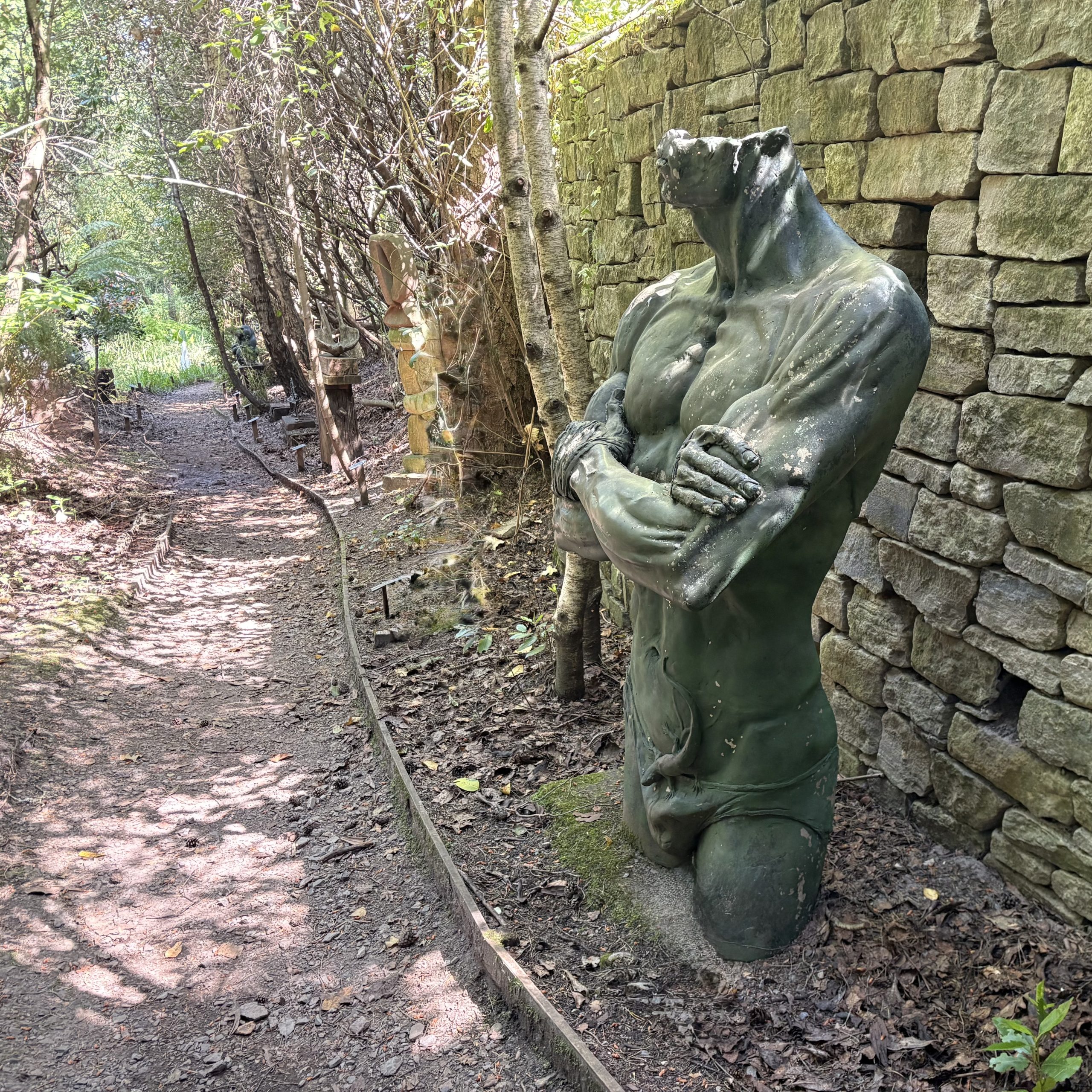 Natura Pudorum Virium Contegit (Nature covers up the shame of strength) by Ian Rank-Broadley is a Monumental Figurative Sculpture of a Man's Torso, arms folded, wearing a Lizard and loin cloth