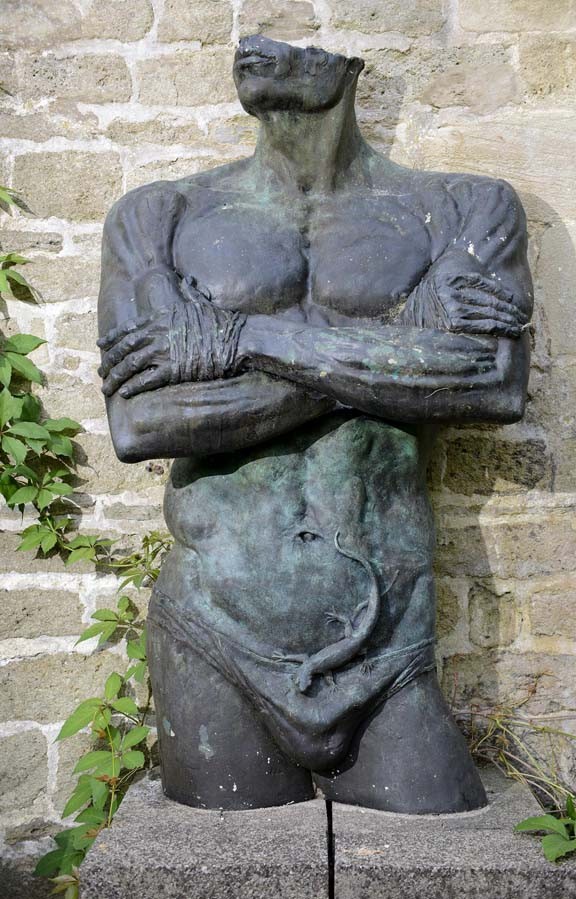 Natura Pudorum Virium Contegit (Nature covers up the shame of strength) by Ian Rank-Broadley is a Monumental Figurative Sculpture of a Man's Torso, arms folded, wearing a Lizard and loin cloth