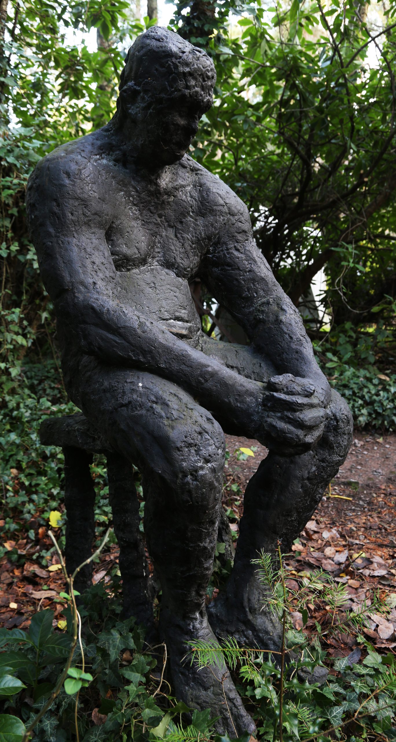 Dave by Sophie White is a figurative bronze resin sculpture of a man sat solemnly on a stool.