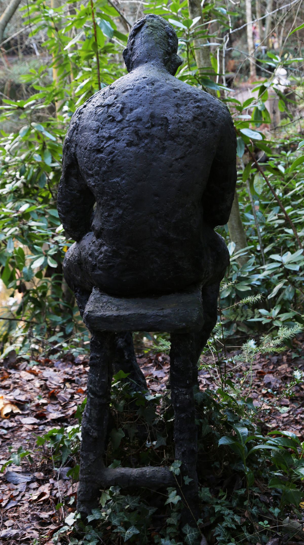 Dave by Sophie White is a figurative bronze resin sculpture of a man sat solemnly on a stool.