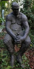Dave by Sophie White is a figurative bronze resin sculpture of a man sat solemnly on a stool.