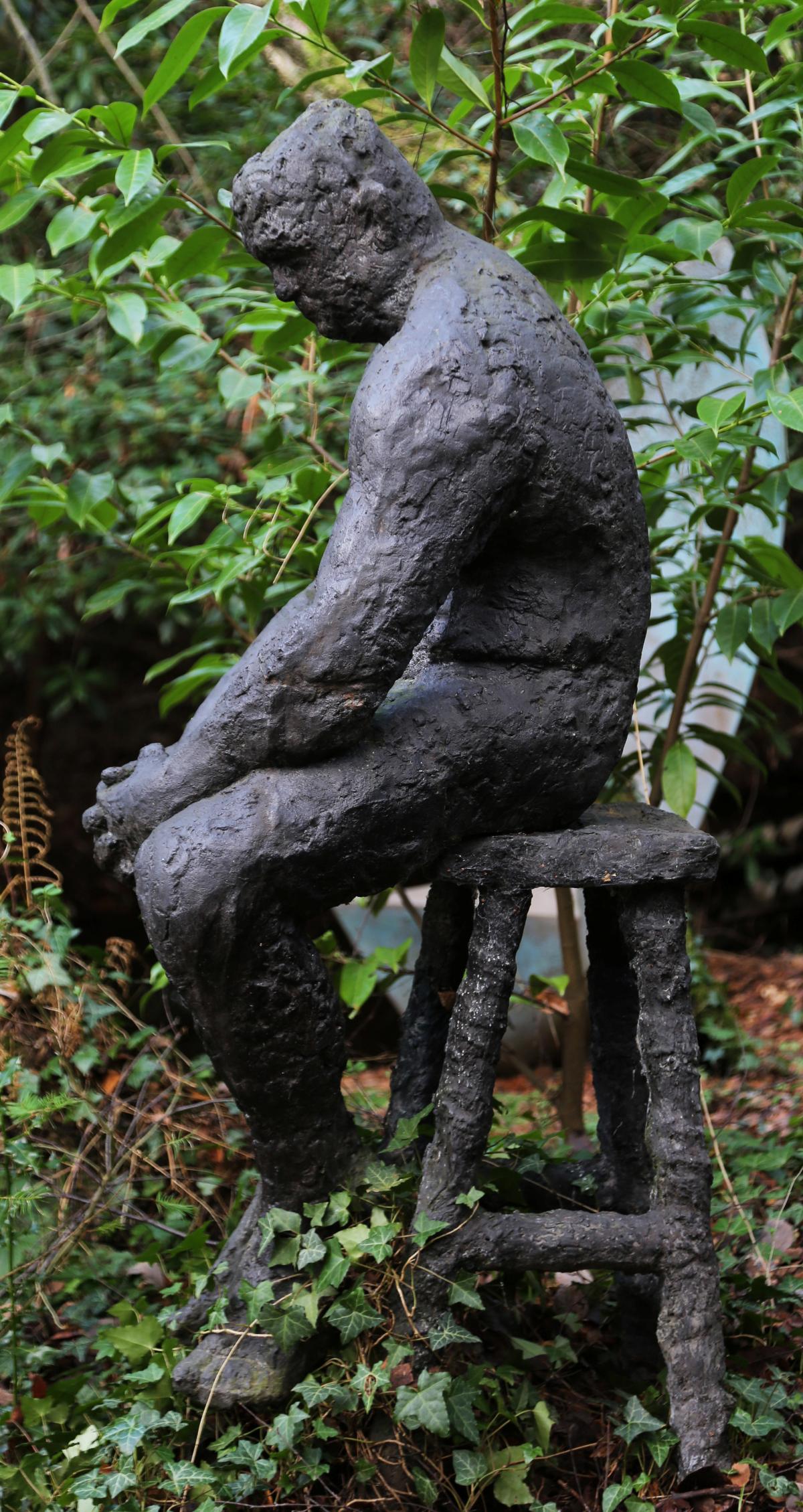 Dave by Sophie White is a figurative bronze resin sculpture of a man sat solemnly on a stool.