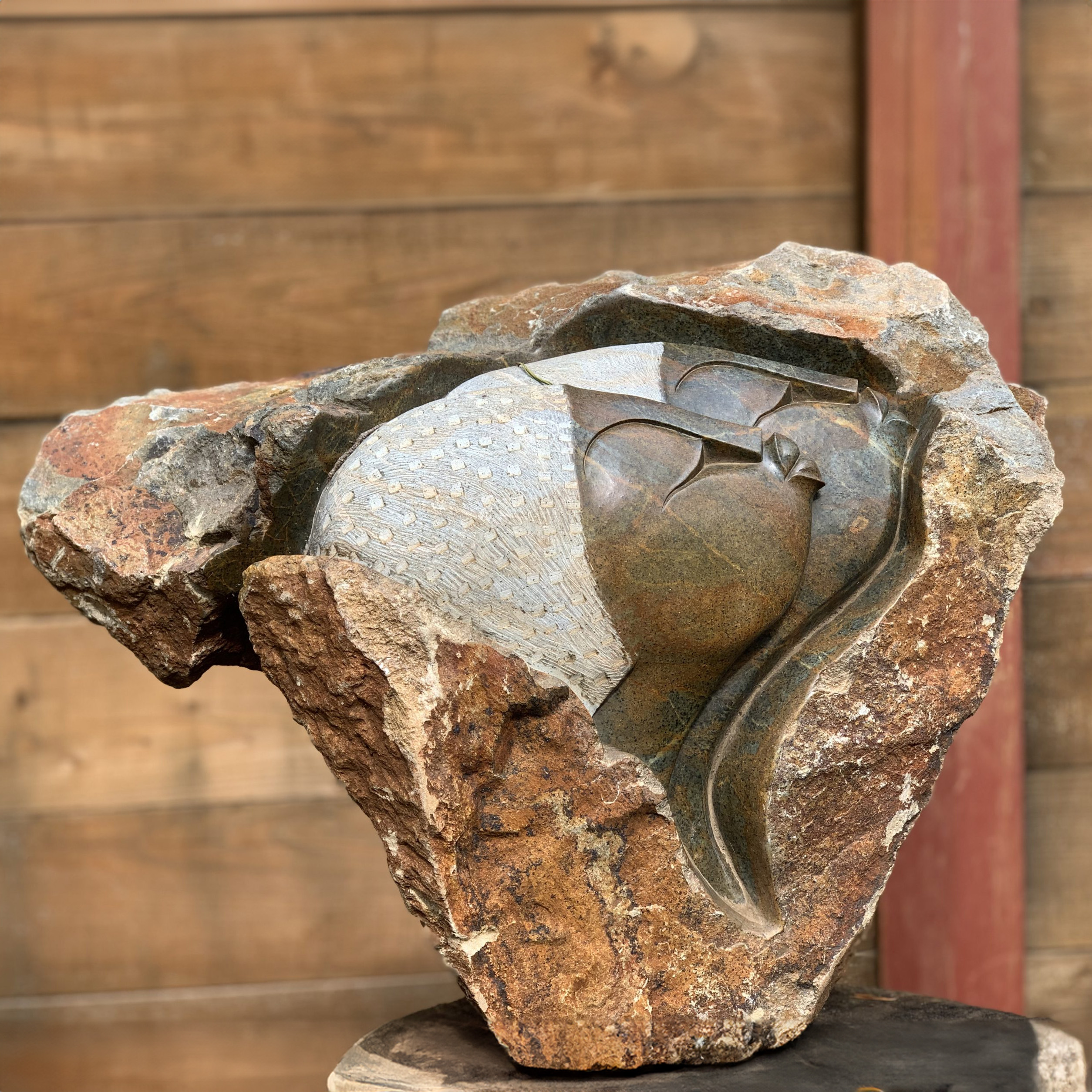 A shona serpentine stone sculpture of two men looking to the side.