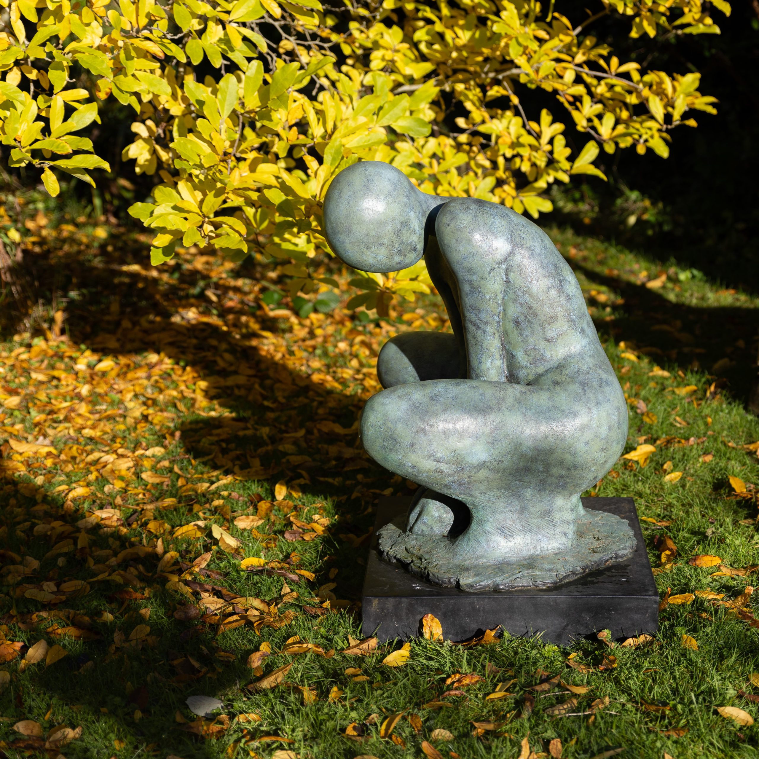 A stylised minimalist sculpture of a crouching woman