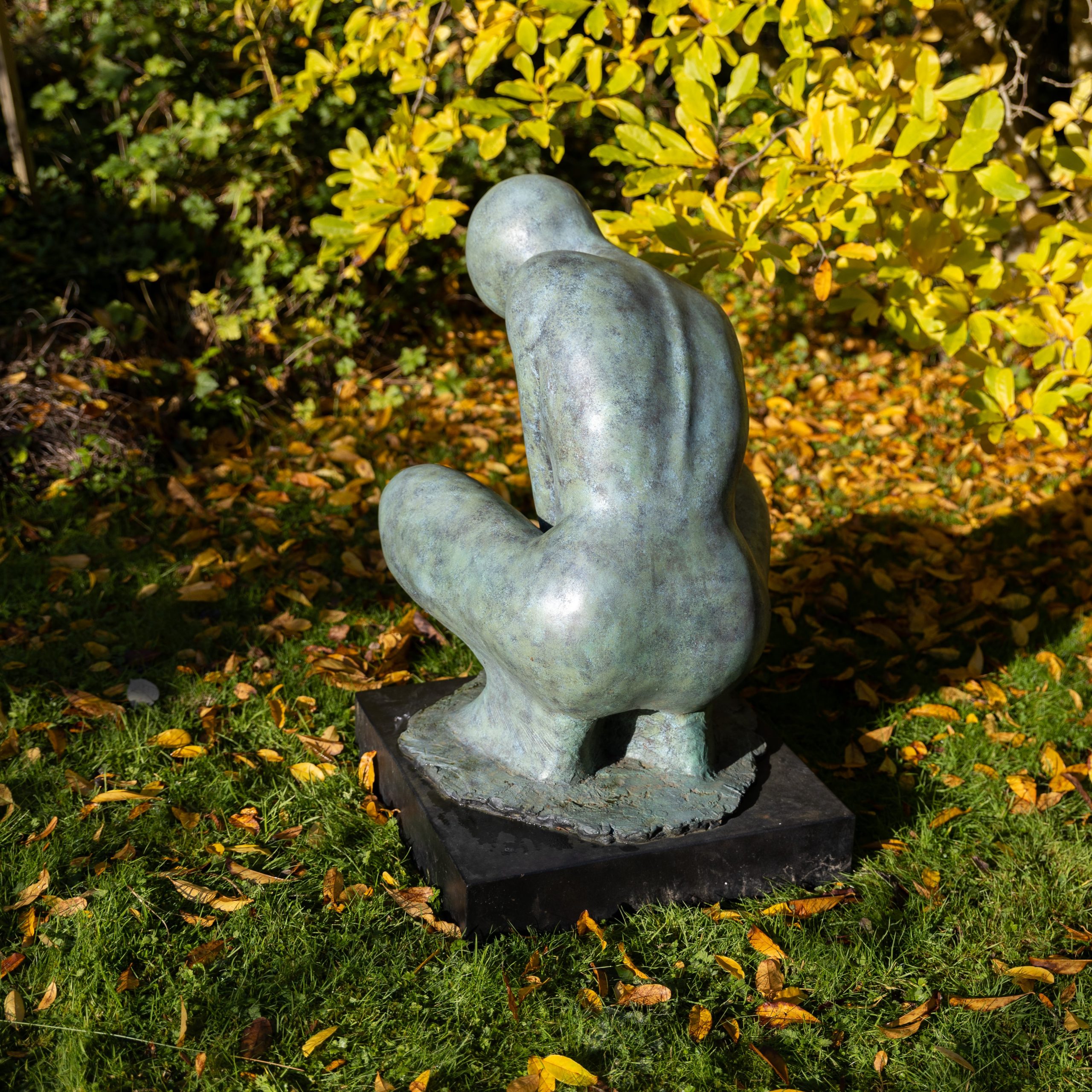 A stylised minimalist sculpture of a crouching woman