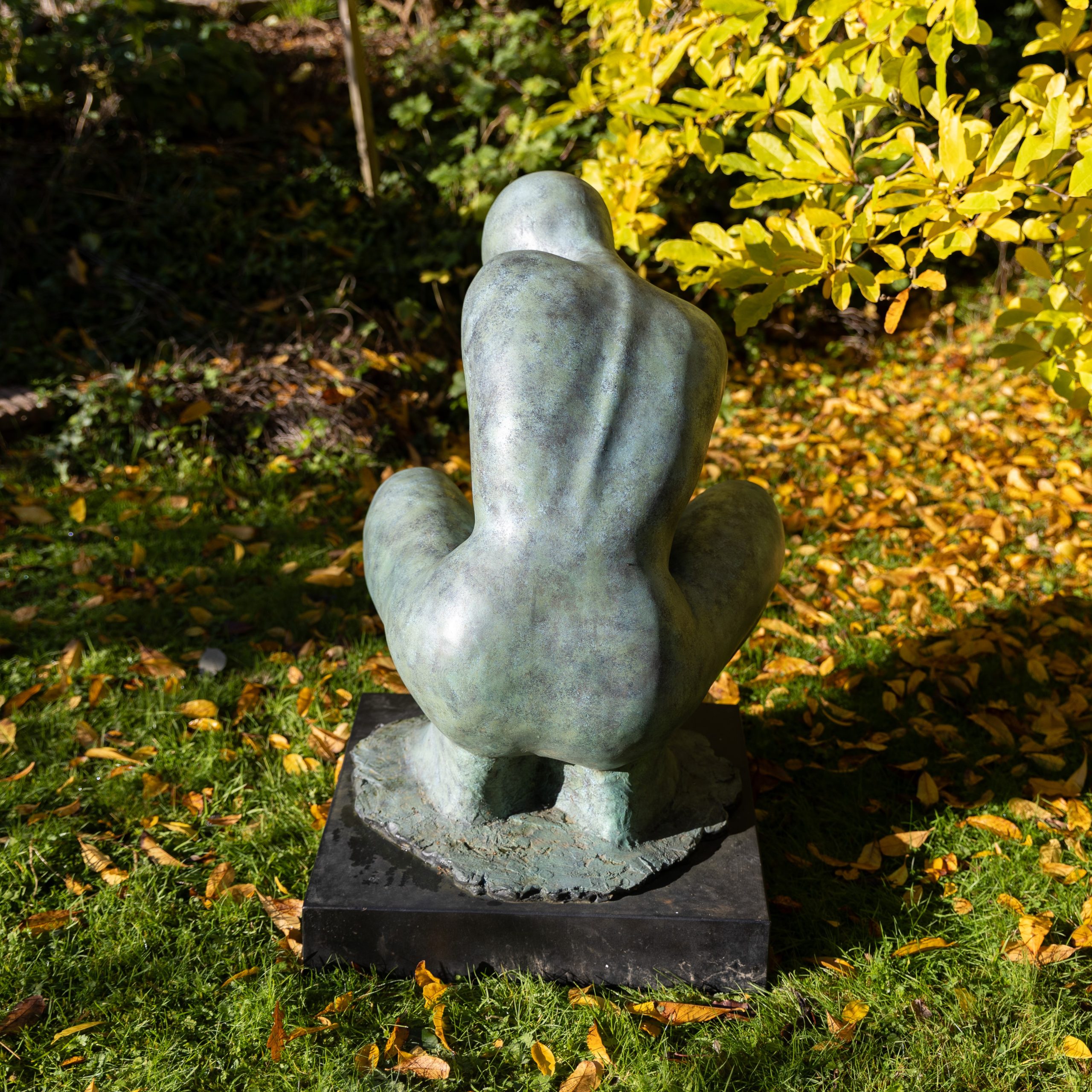A stylised minimalist sculpture of a crouching woman