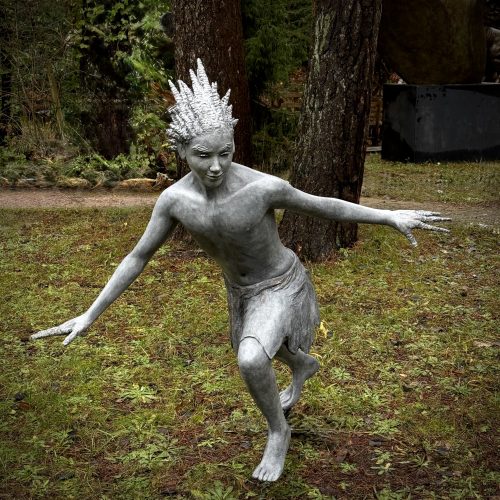 Jack Frost by Graeme Lougher. Bronze resin sculpture of male folklore figure personifying freezing cold. Pale grey patina and cautious, creeping stance and frozen hair and eyebrows.