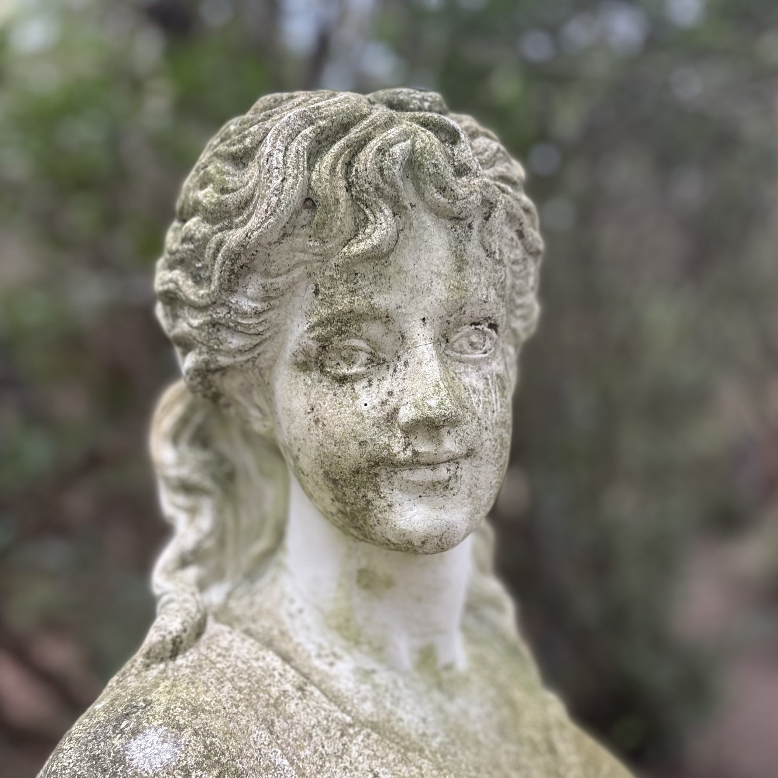 Lady Carrying Baskets by After The Antique is a cast stone, weather-aged sculpture of a girl going to market suitable for outdoor display