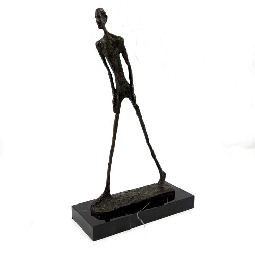 Walking Man by In the style of Alberto Giacometti. Bronze sculpture of a man walking, created in the style of Giacometti, with a simplified, elongated form