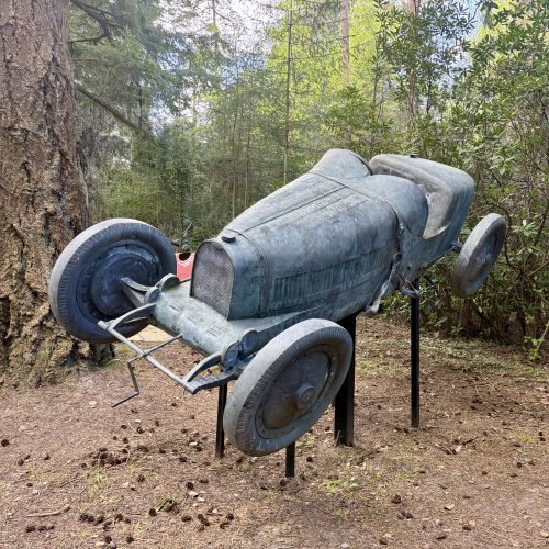 Bugatti Type 35 by by Francois Chevalier is a life-size bronze racing car sculpture, positioned as if lifting off the ground, speeding round a corner