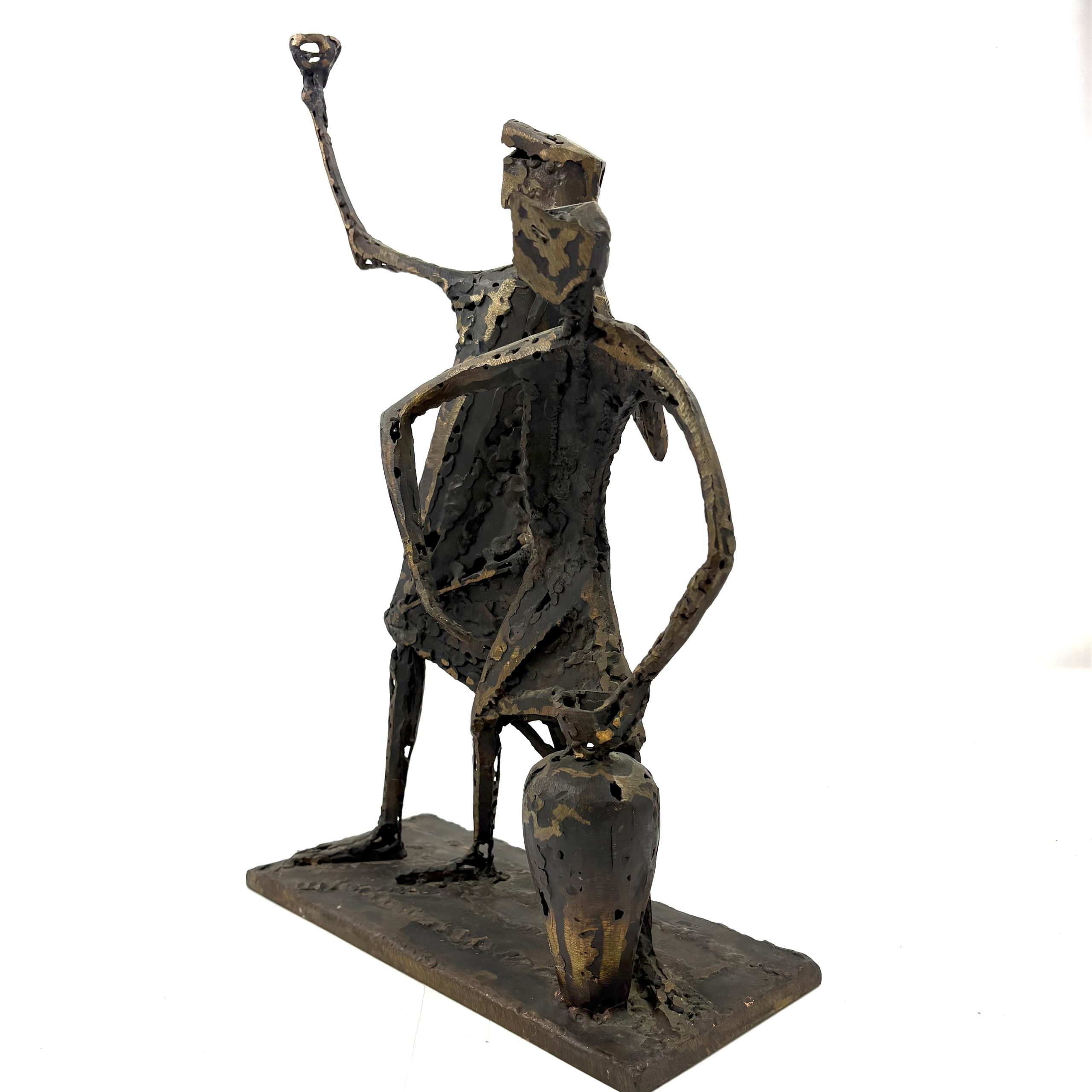Two Figures by Sean Crampton. A unique sculpture made from welded bronze depicting two figures standing side by side along with a large vessel or vase.
