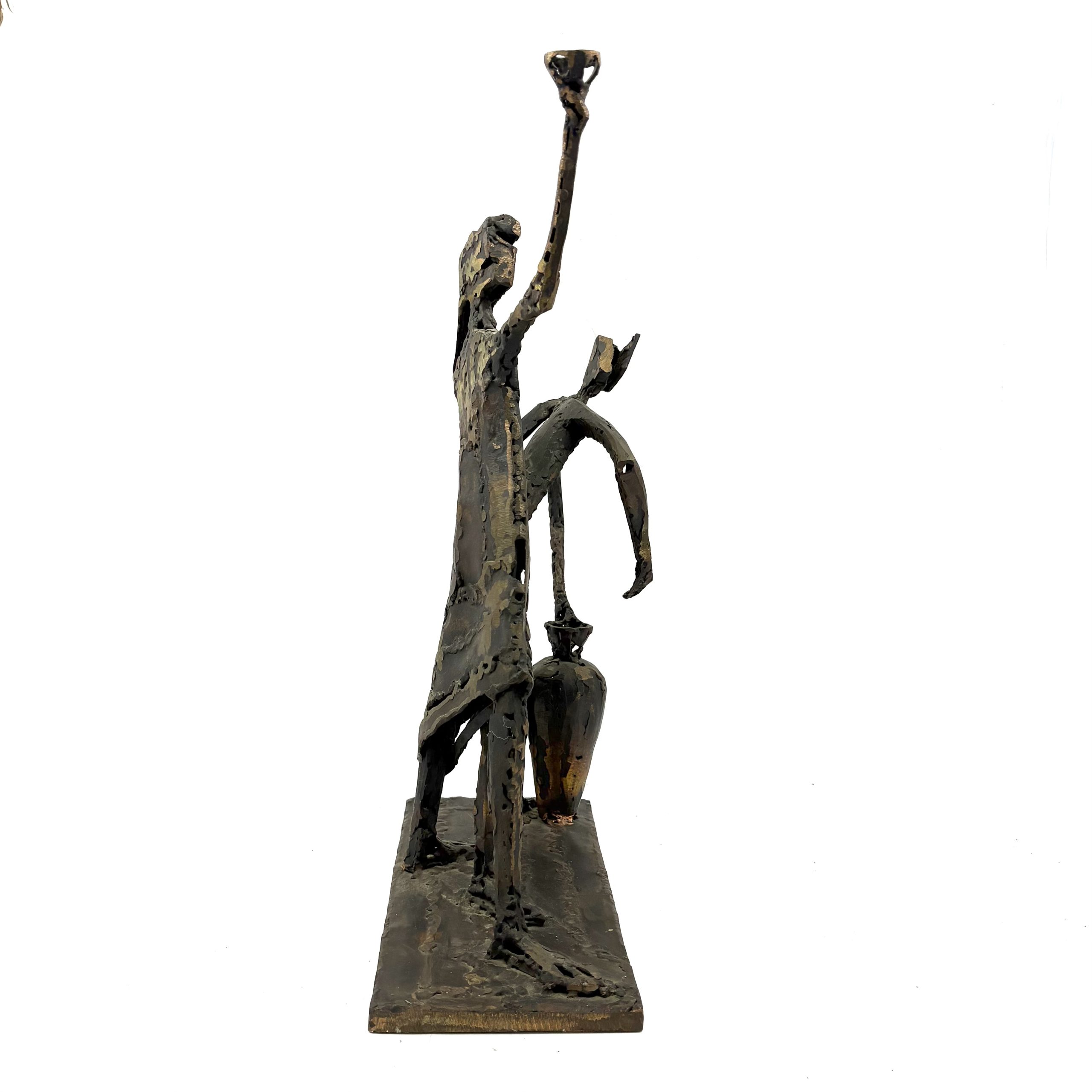 Two Figures by Sean Crampton. A unique sculpture made from welded bronze depicting two figures standing side by side along with a large vessel or vase.