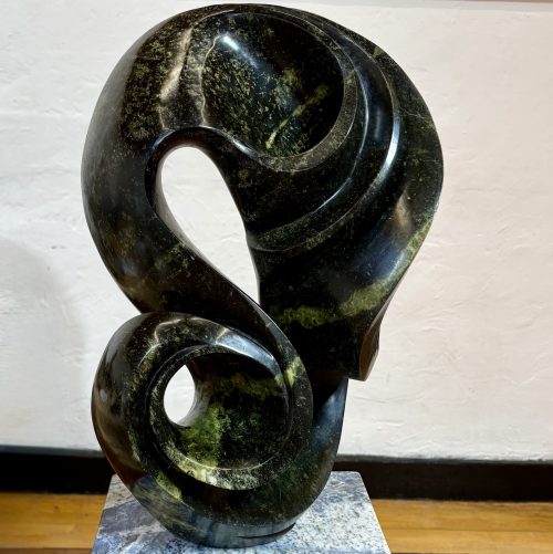 Life on Earth by Kufa McDonald. Unique sculpture made from avocado stone with green hues. The piece swirls and curves in an abstract yet naturalistic style.
