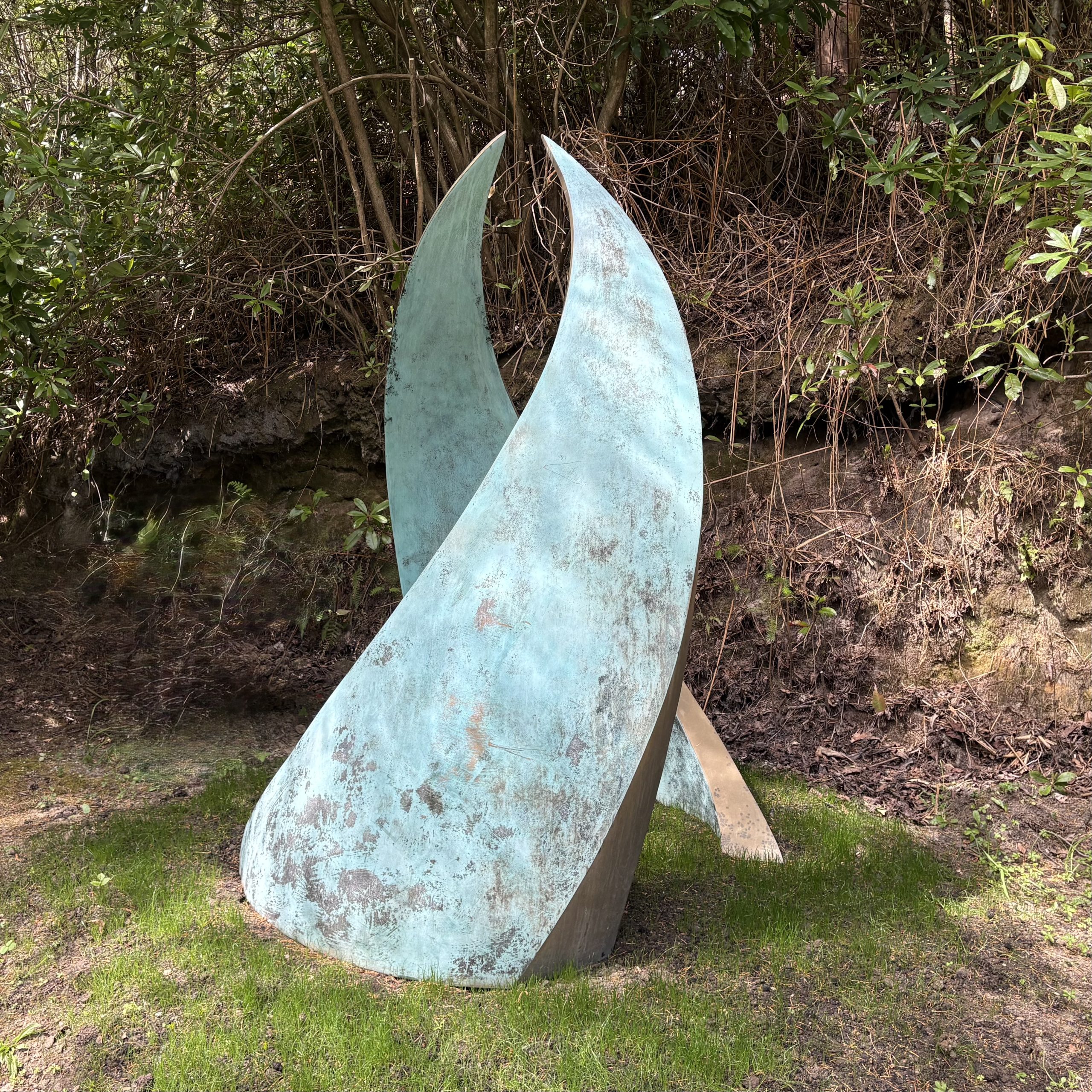 Embrace by Simon Gudgeon. Monumental abstract bronze sculpture of two wave like two forms that arch in towards each other.