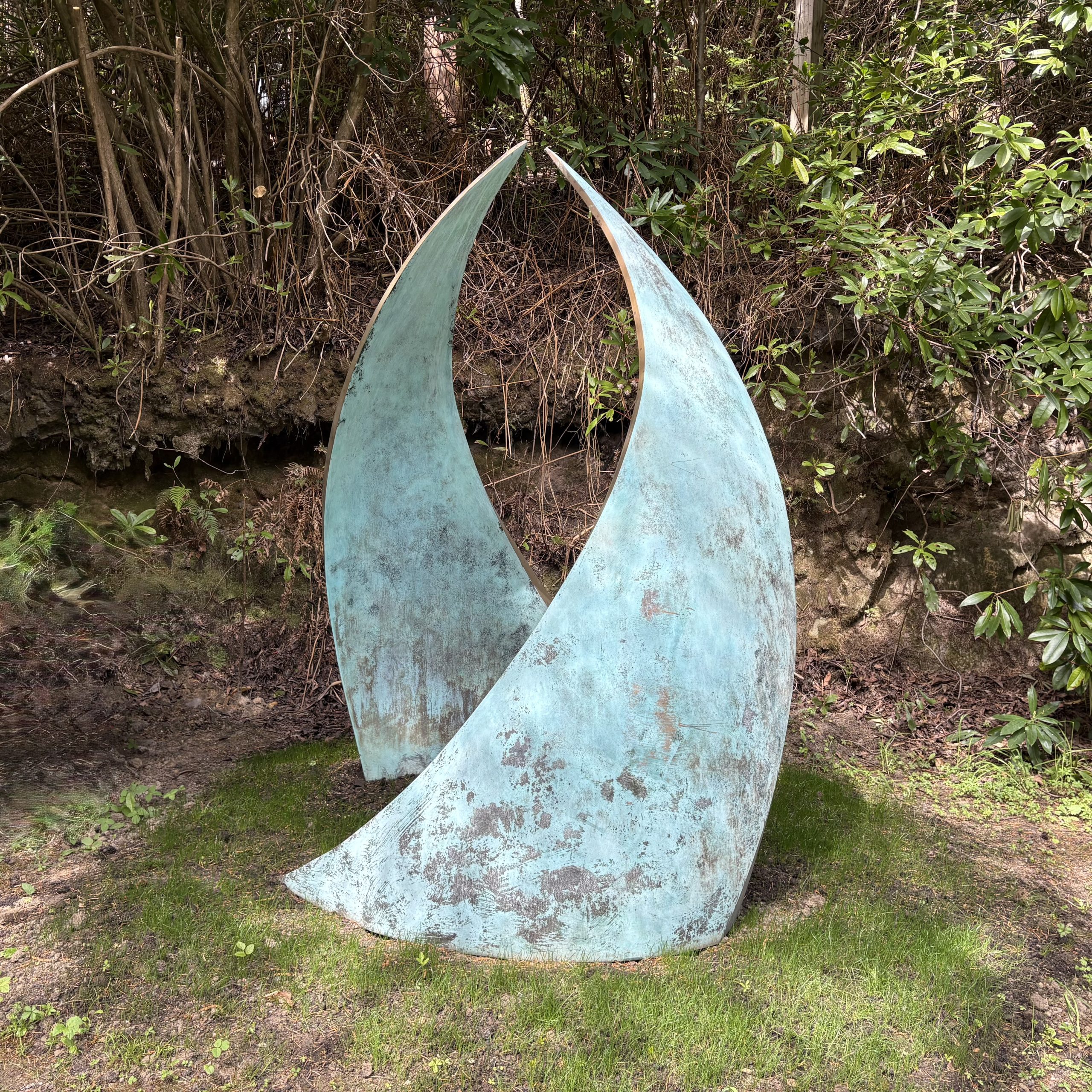 Embrace by Simon Gudgeon. Monumental abstract bronze sculpture of two wave like two forms that arch in towards each other.
