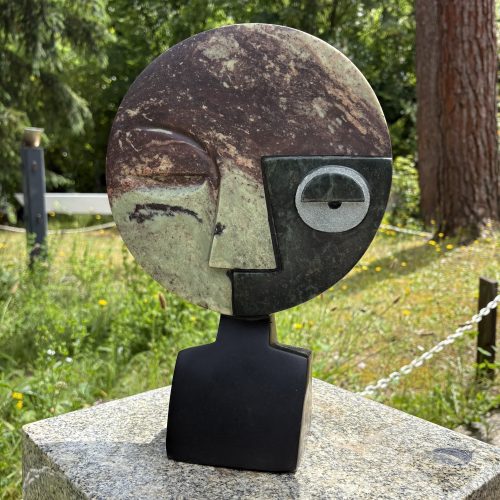 Visionary by Taylor Nkom. A unique, Cobalt, Opal and Springstone Shona sculpture of an abstract style face. The different stones add definition and colour.