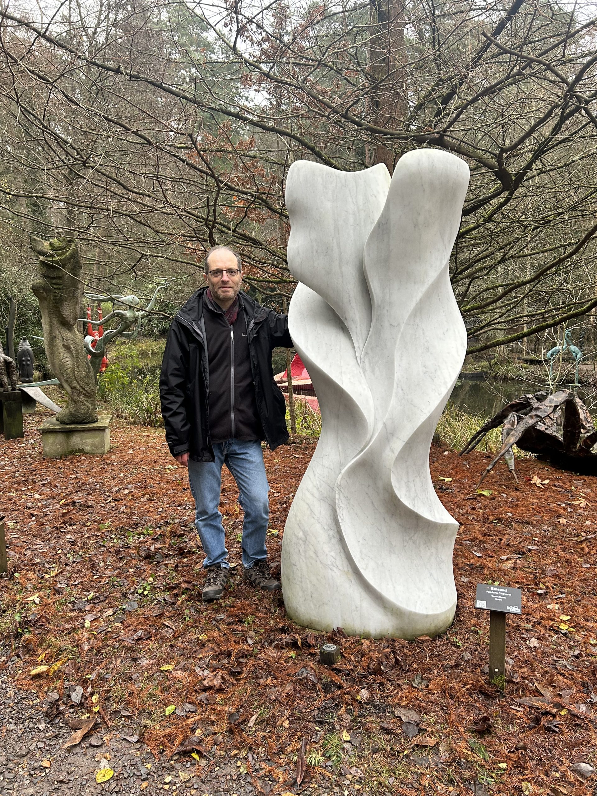 Enlaced by Frederic Chevaric. Large white abstract marble sculpture with wave like carved formations.