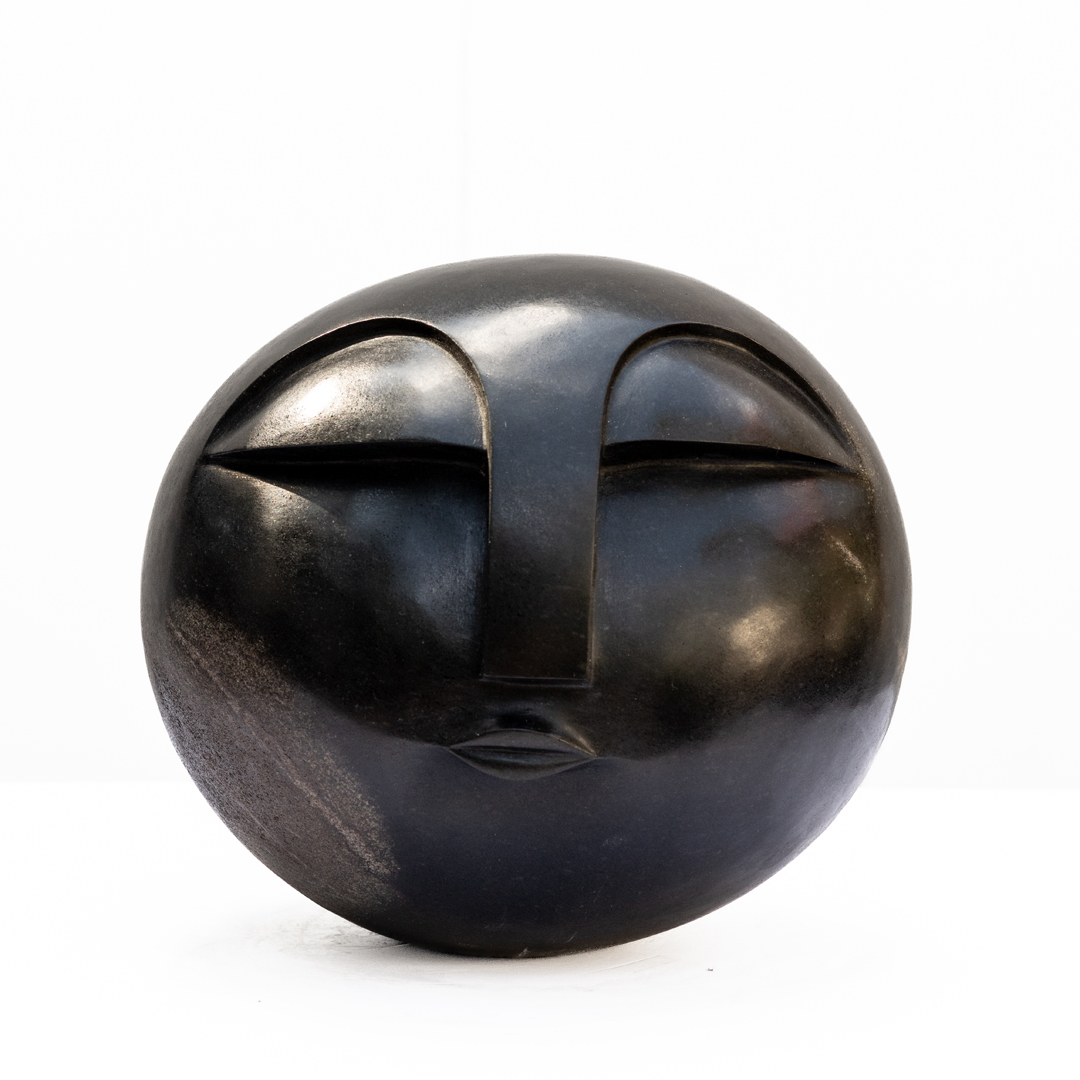 Sun Face by Addington Nyamasoka, a Shona Springstone sculpture of a rounded head with a face.