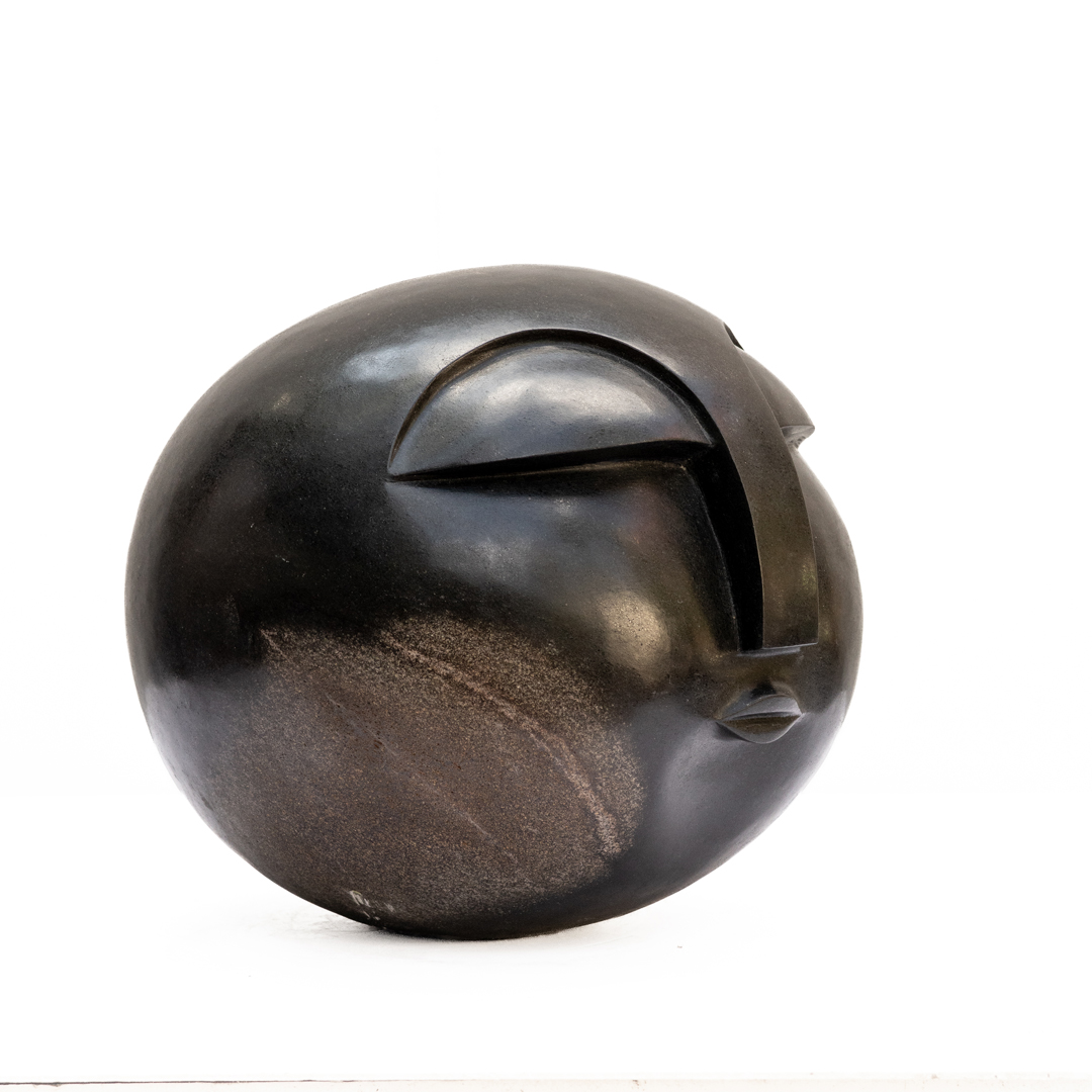Sun Face by Addington Nyamasoka, a Shona Springstone sculpture of a rounded head with a face.