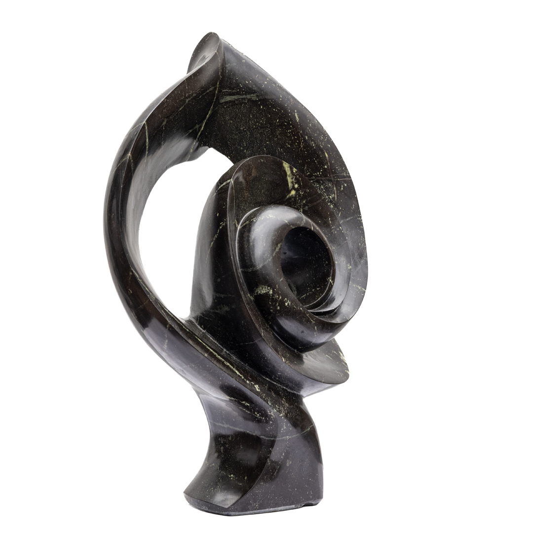 Enticing by Evison Nyamasoka. Unique table-top sized abstract Shona sculpture, hand carved from avocado stone. The stone swirls around a hole in the centre.