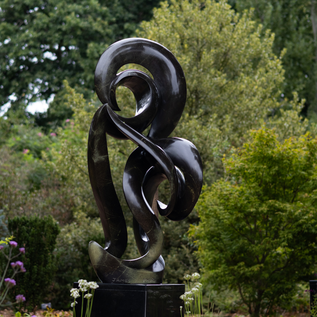 Cherished by James Phiri, a Shona Avocado stone sculpture of a tall abstract shape that curls and twists as it rises.