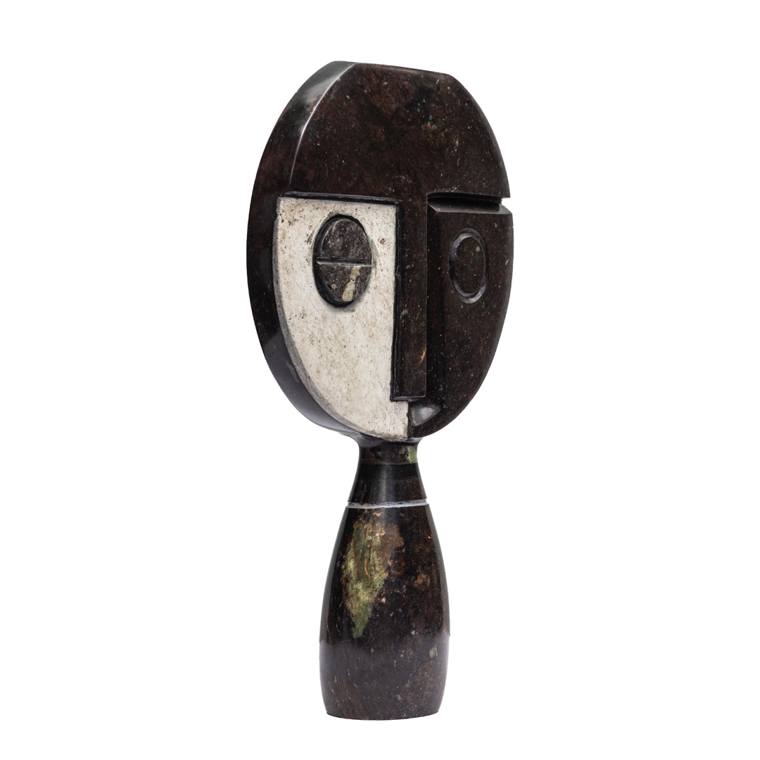 Visionary by Taylor Nkomo, a Shona Cobolt stone, Sapolite stone, and Sprinstone sculpture of a abstract face with two different coloured sides to its face.