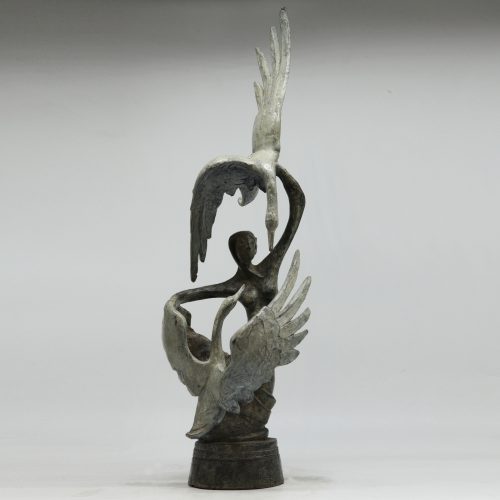 Girl with Two Geese by Sean Crampton, a figurative bronze sculpture of a female figure with a pair of white geese flying around her.