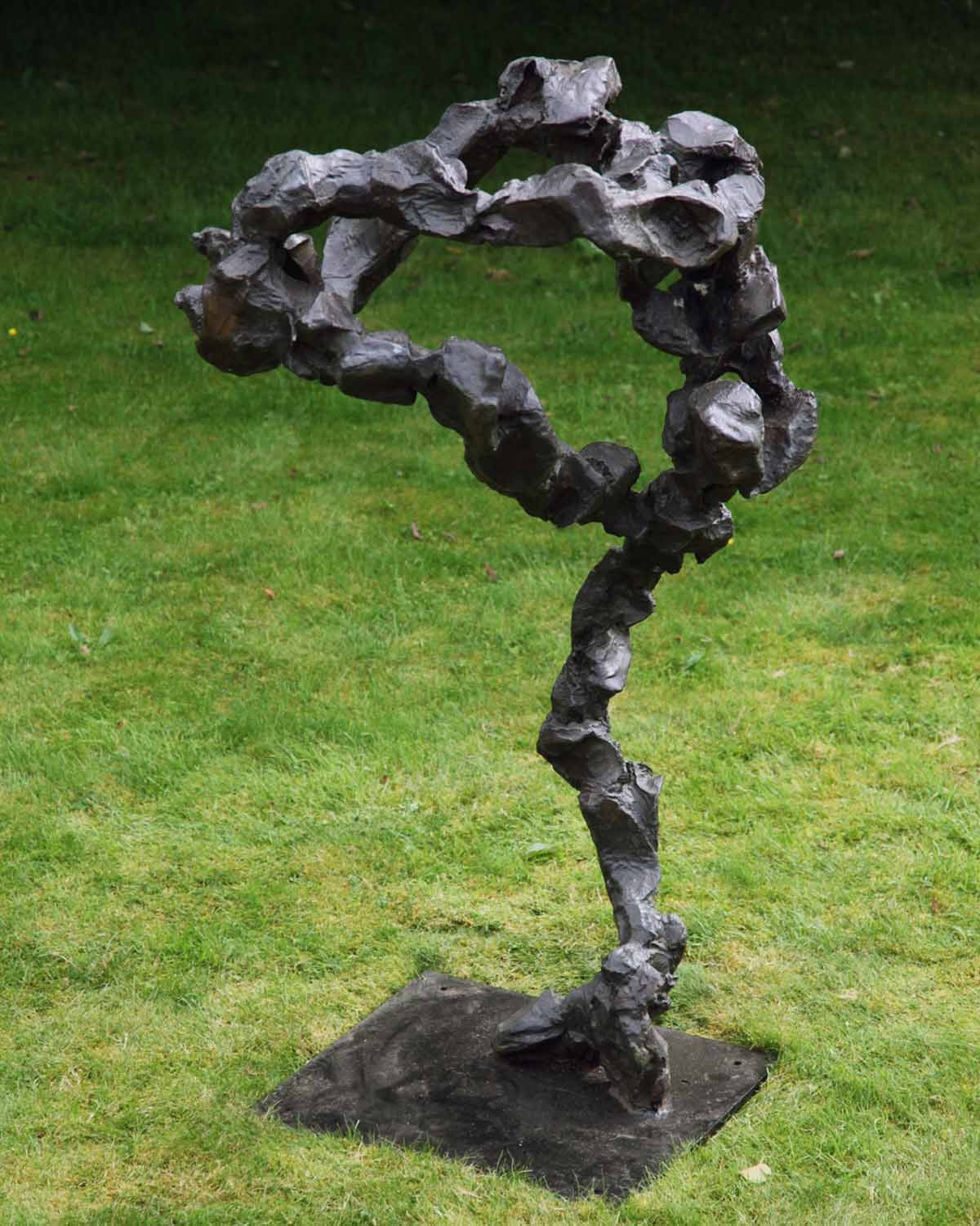 A abstract bronze sculpture of a long uneven shape.