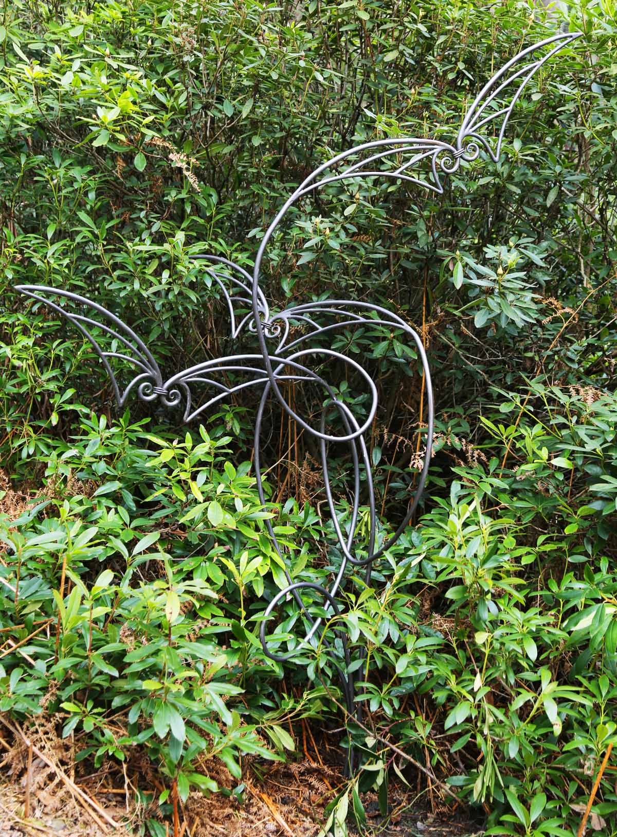 A minimalist forged steel sculpture of a group of wire butterflies.