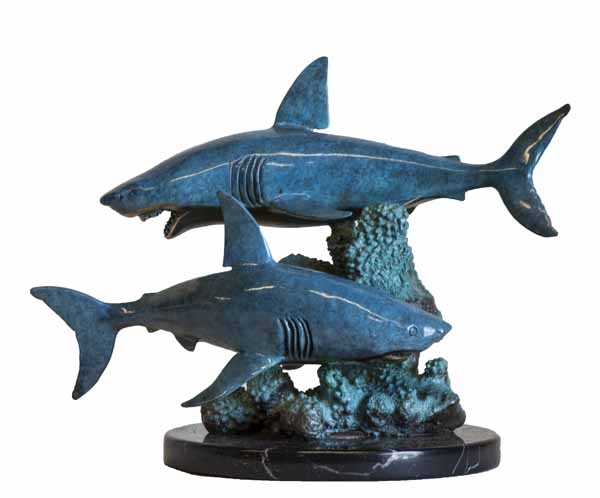 A figurative bronze and marble sculpture of a pair of blue sharks swimming around a reef.