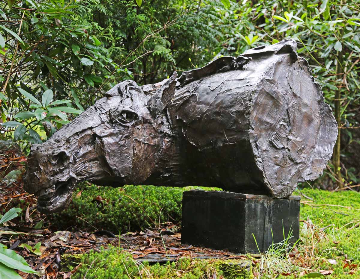 A bronze portraiture sculpture of a horse head turned to the side with it's ears pinned back.