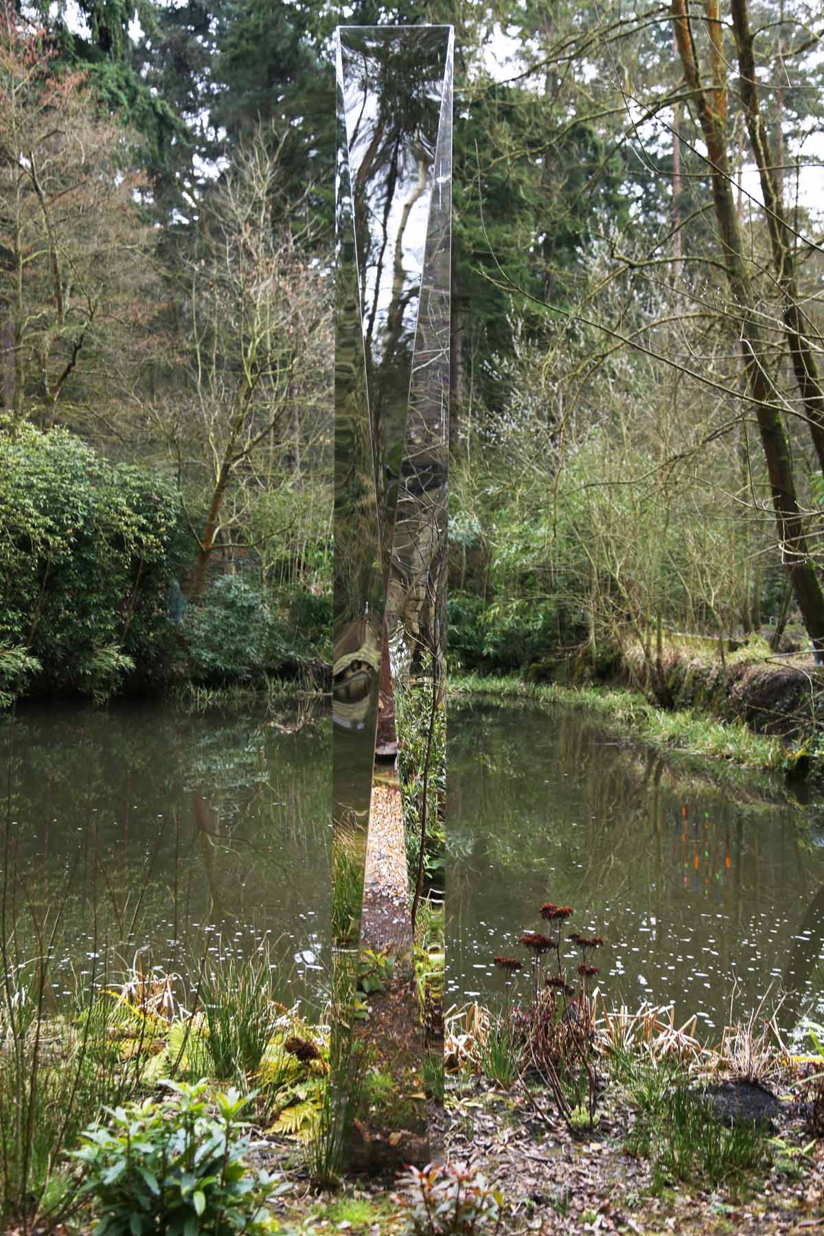 A cubism stainless steel sculpture of a tall abstract reflective surface.