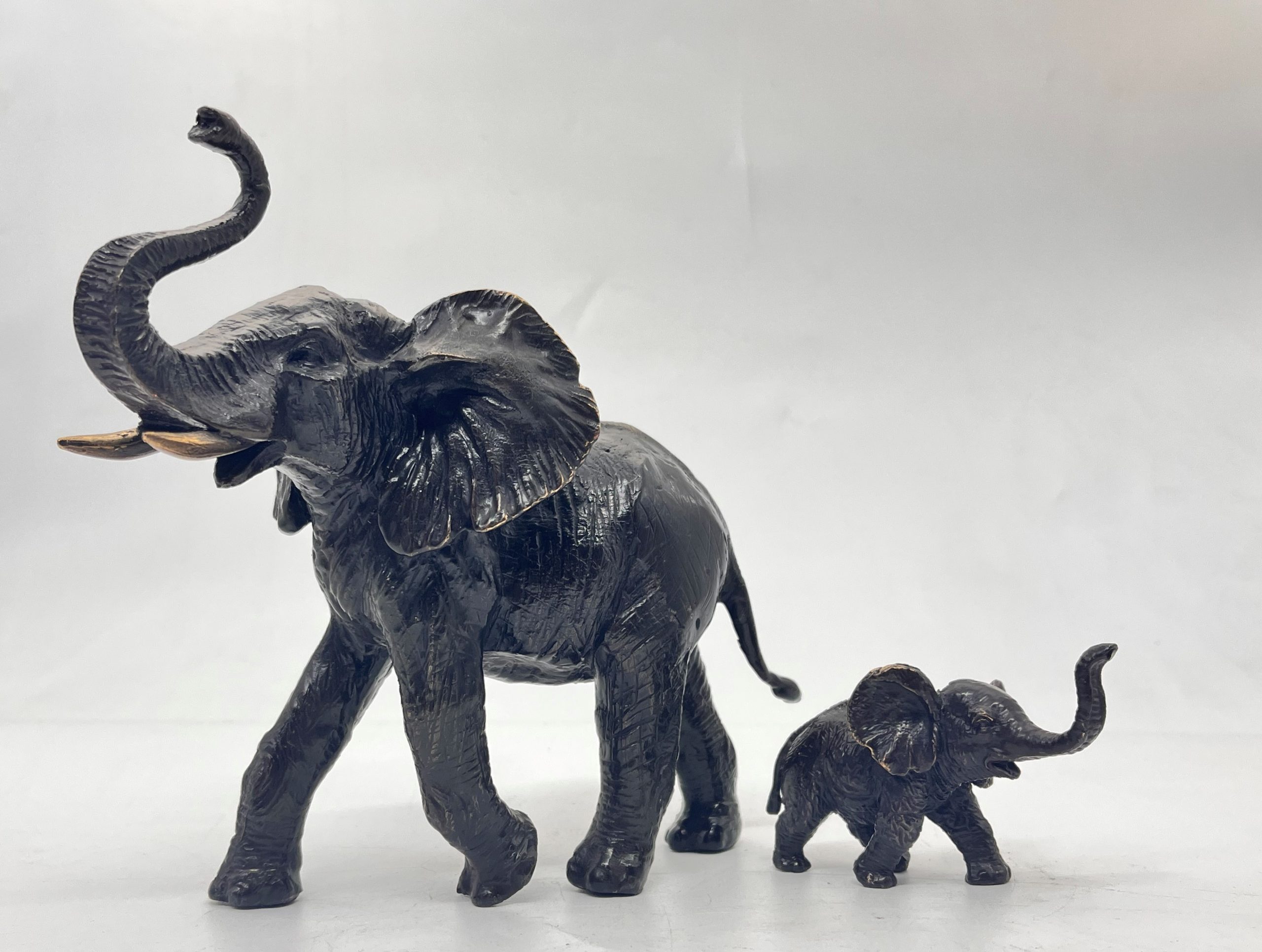 A decorative bronze resin sculpture of an African elephant and calf.