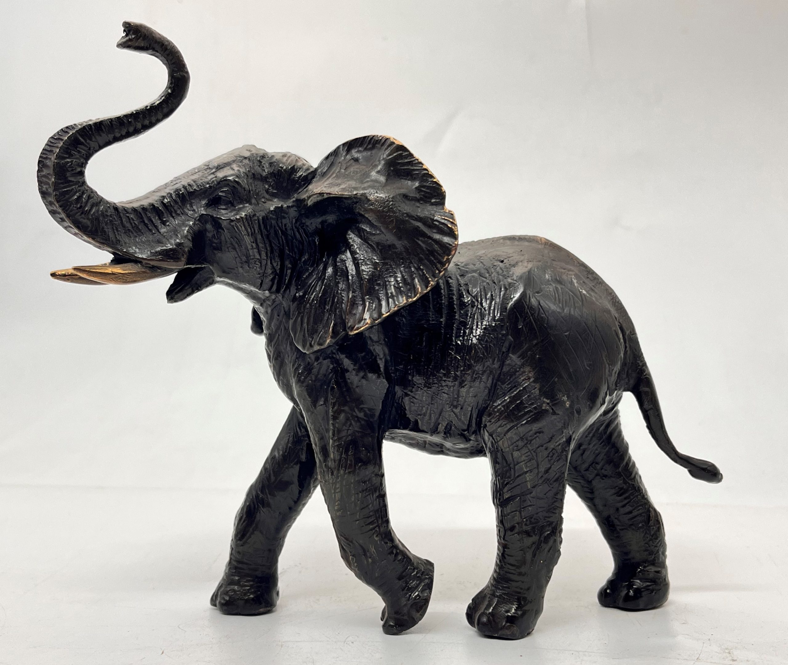 A decorative bronze resin sculpture of an African elephant and calf.