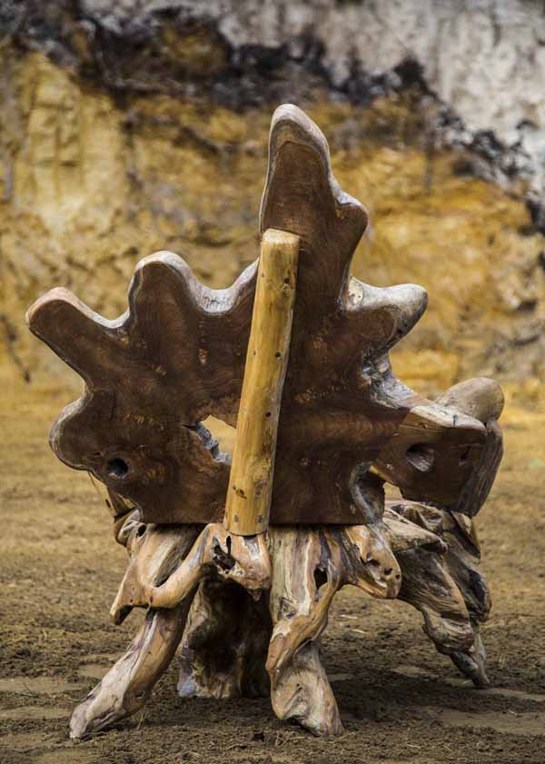 A furniture teak wood sculpture of a arm chair made from a tree root.