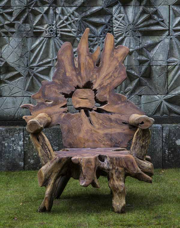 A furniture teak wood sculpture of a arm chair made from a tree root.