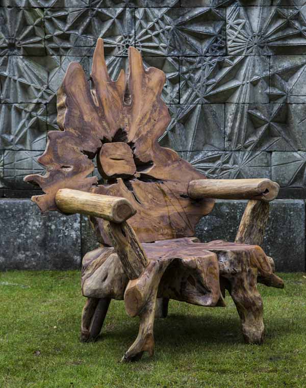 A furniture teak wood sculpture of a arm chair made from a tree root.