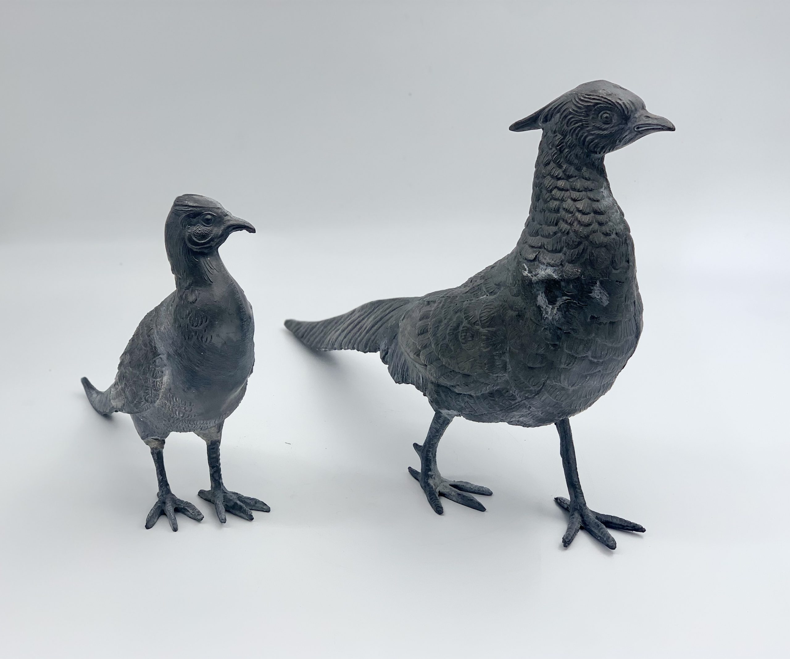 Two realism lead sculptures of a male and female pair of standing pheasants