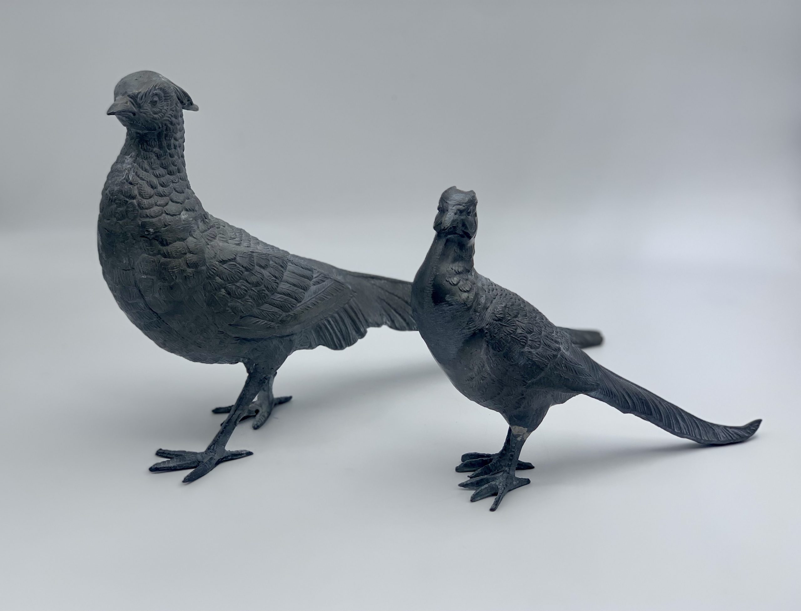Two realism lead sculptures of a male and female pair of standing pheasants