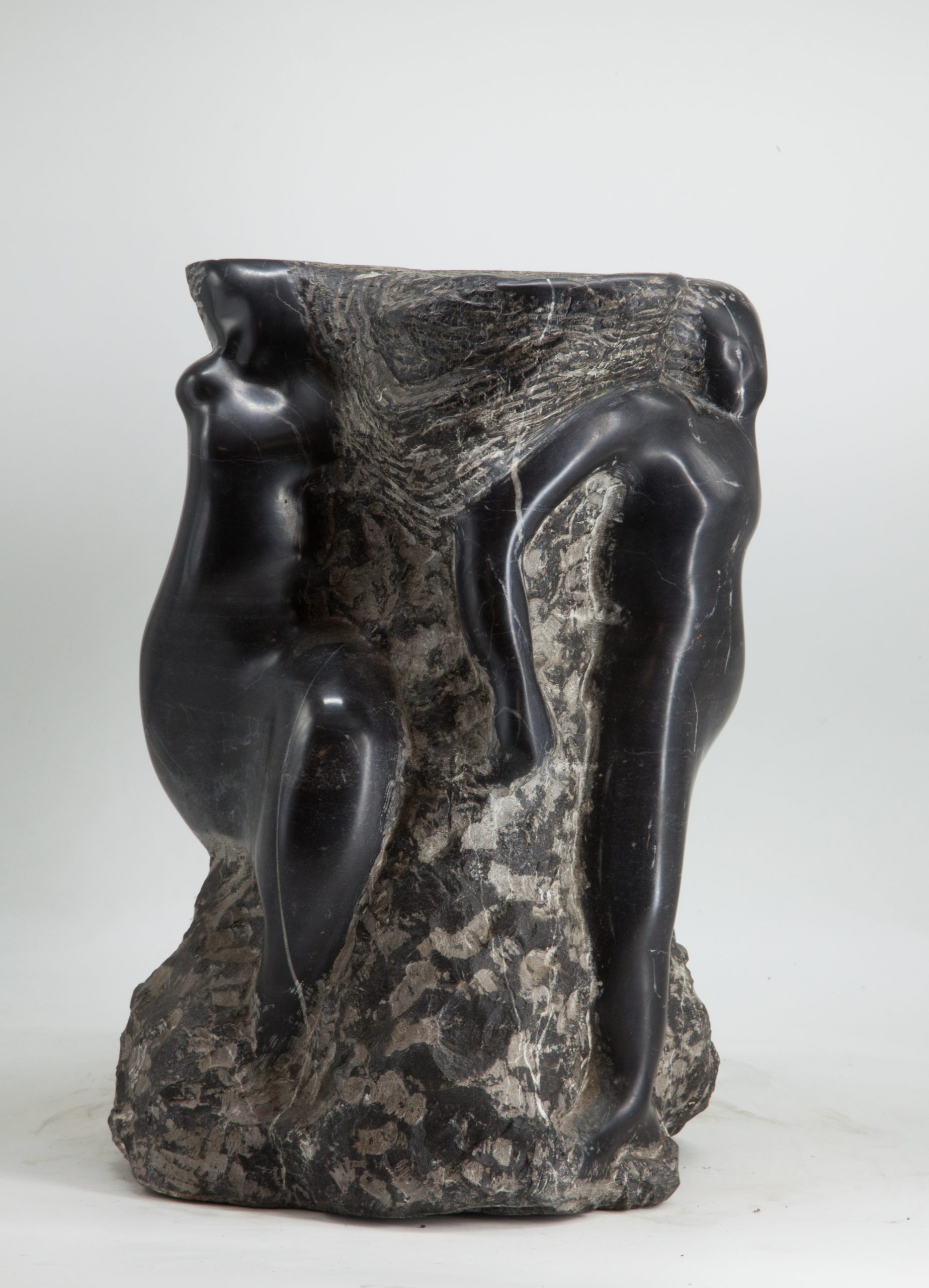 An abstract and modern sculpture depicting figures emerging from the marble.