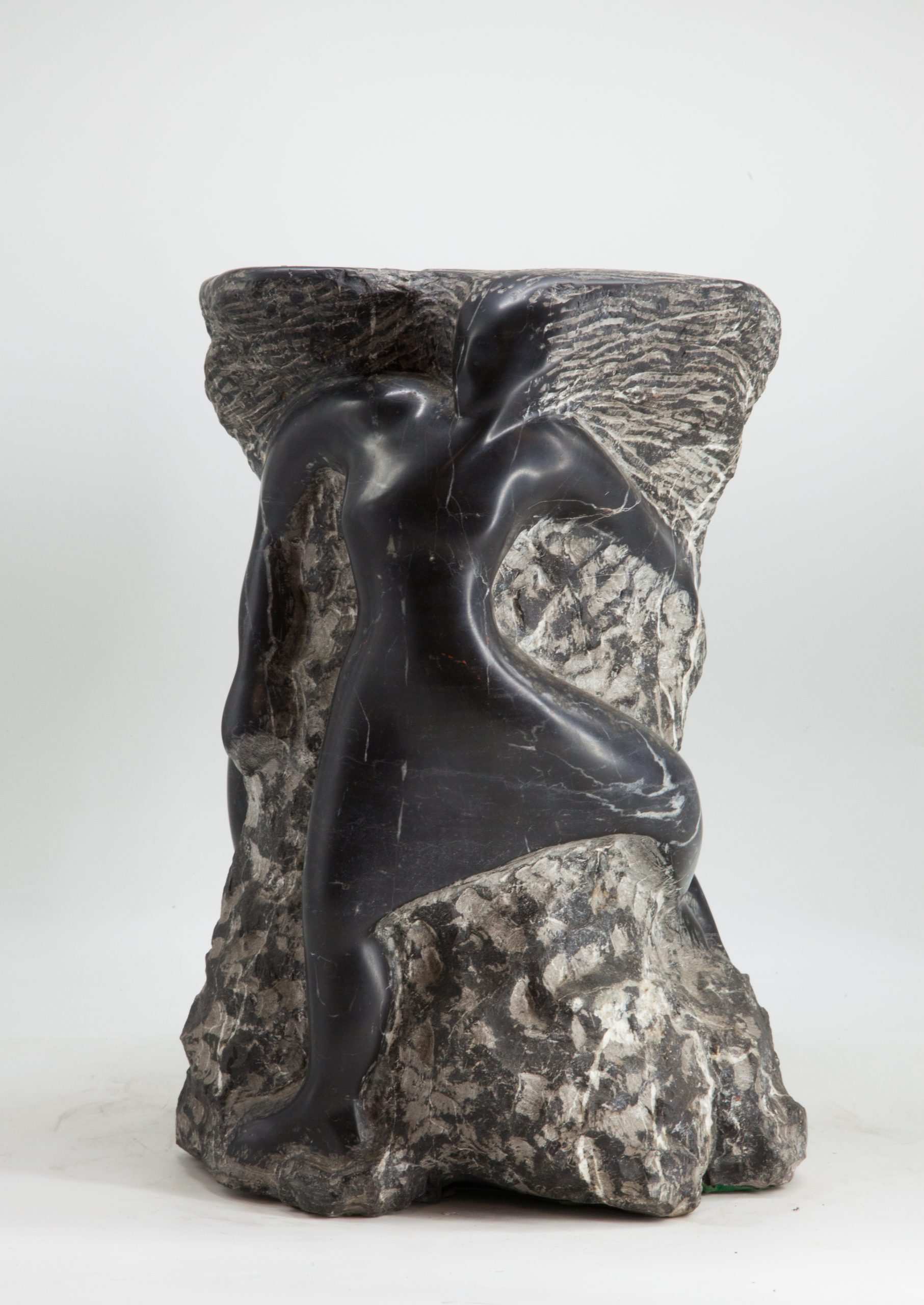 An abstract and modern sculpture depicting figures emerging from the marble.