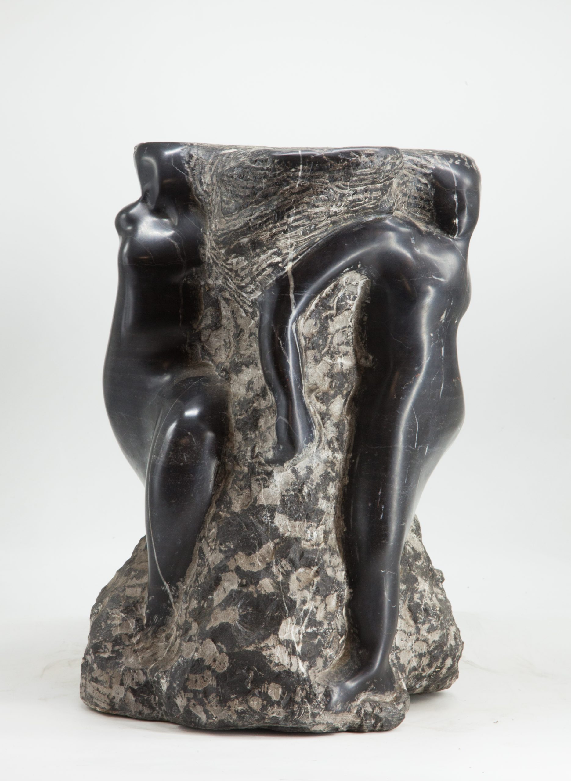 An abstract and modern sculpture depicting figures emerging from the marble.