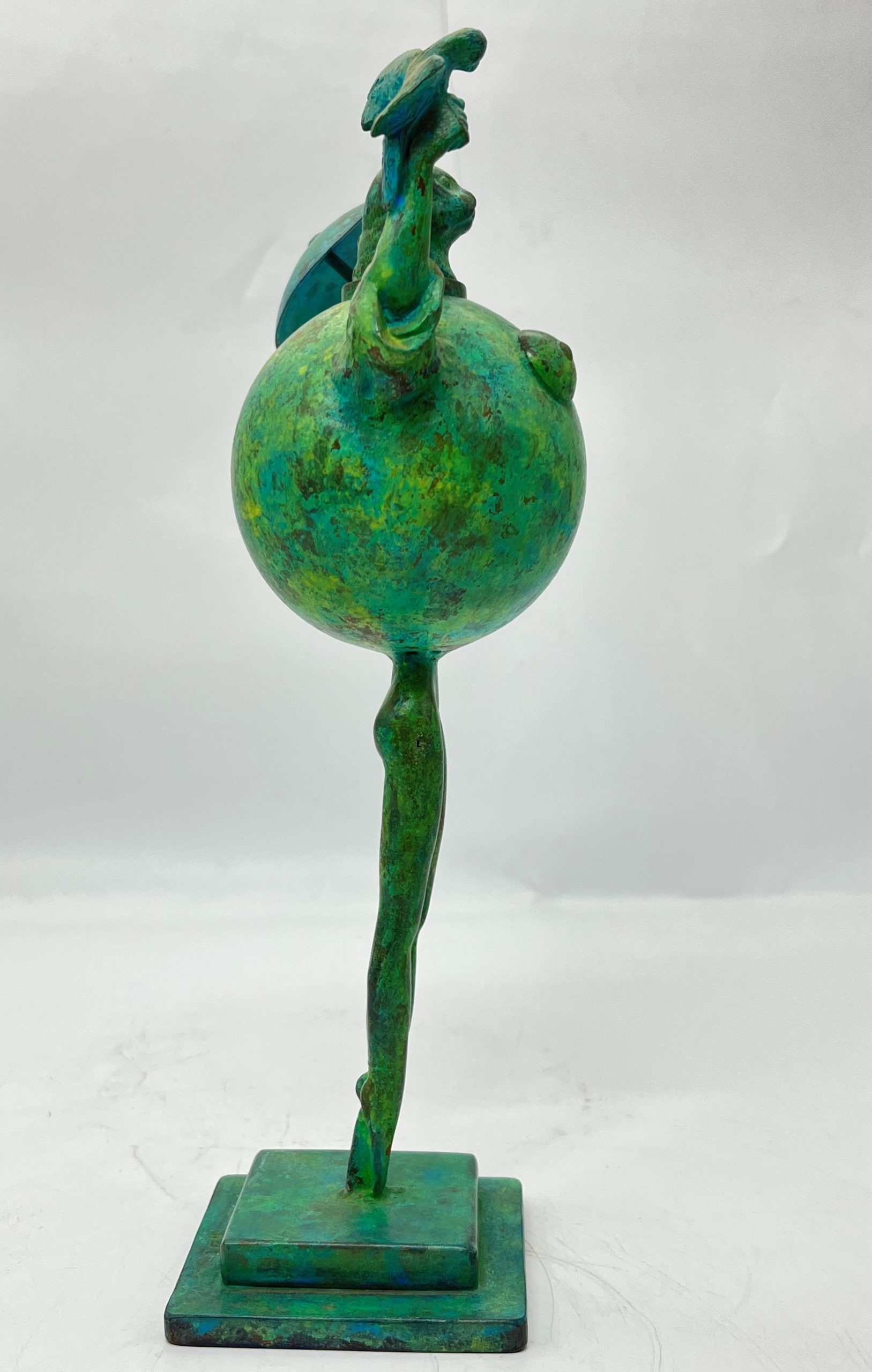 A modern and abstract smaller scale sculpture of a cat stood up straight whilst holding a bird in one hand and an umbrella in the other.