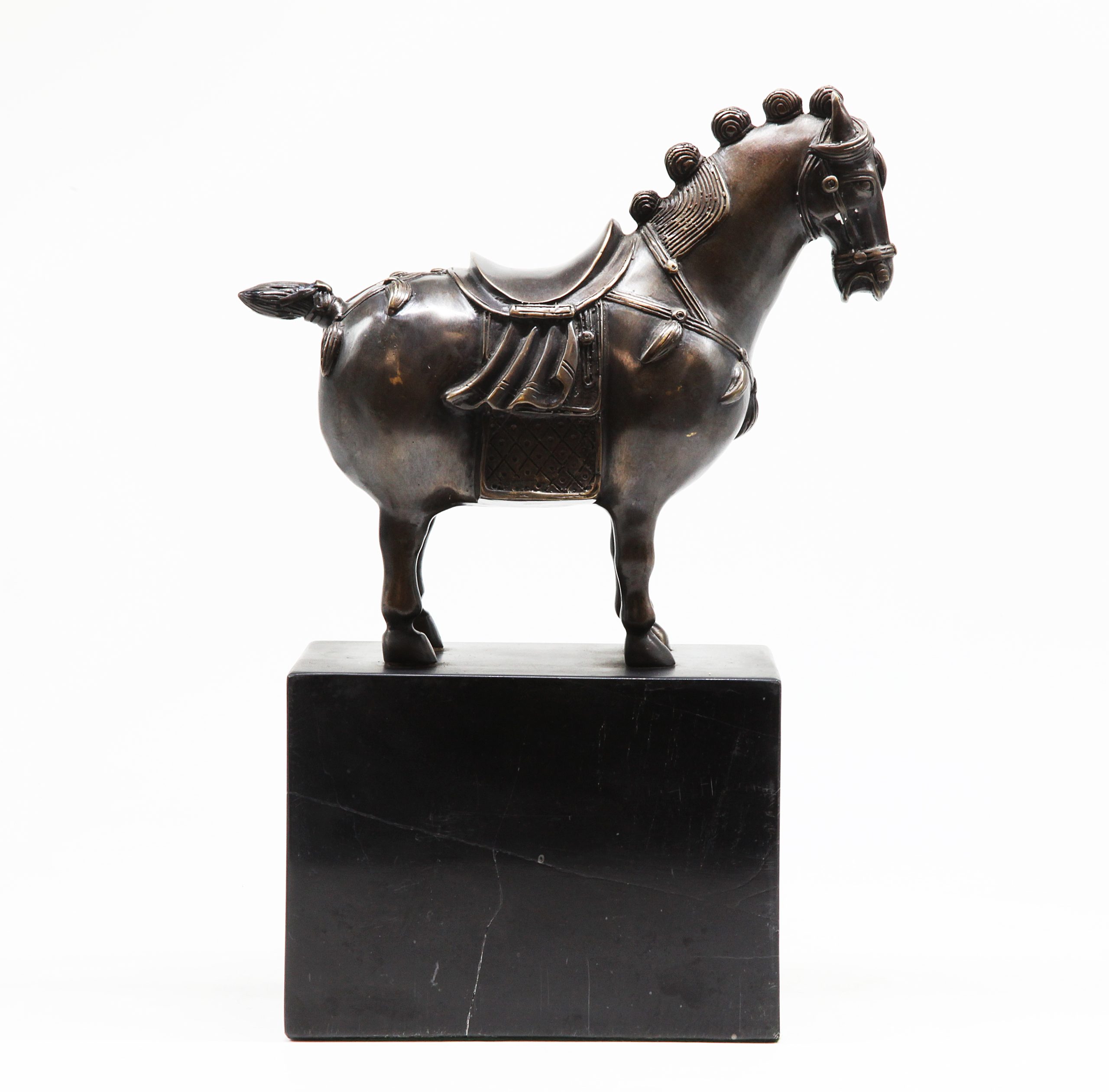 A figurative bronze sculpture of a decorative horse on top of a marble cube.